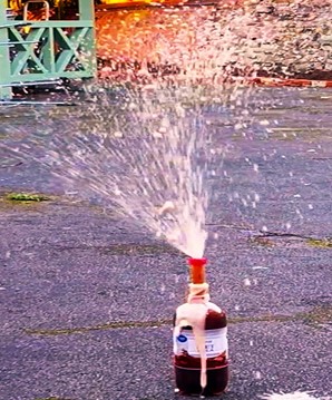 A bottle of Coca-Cola splutters all over a car park after some Menthos were dropped in the top