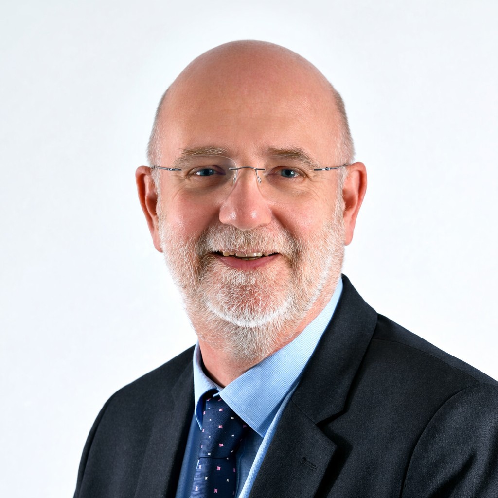 Cliff Christie with beard, smiling to camera wearing suit, shirt and tie and glasses