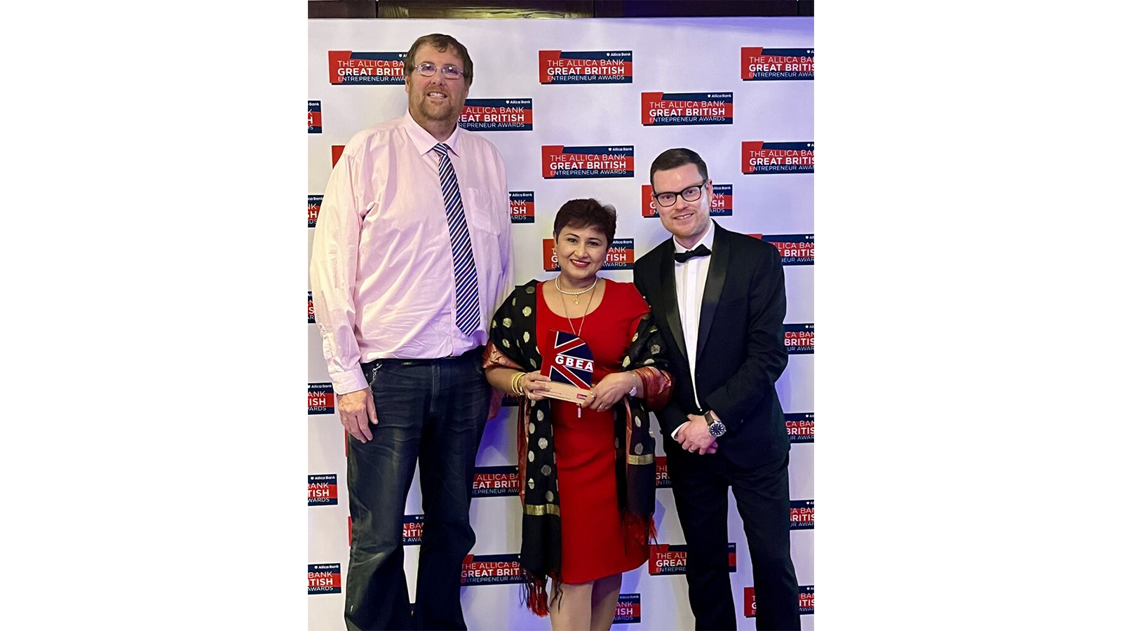 Professor Damion Corrigan with others and with a prize trophy at an event