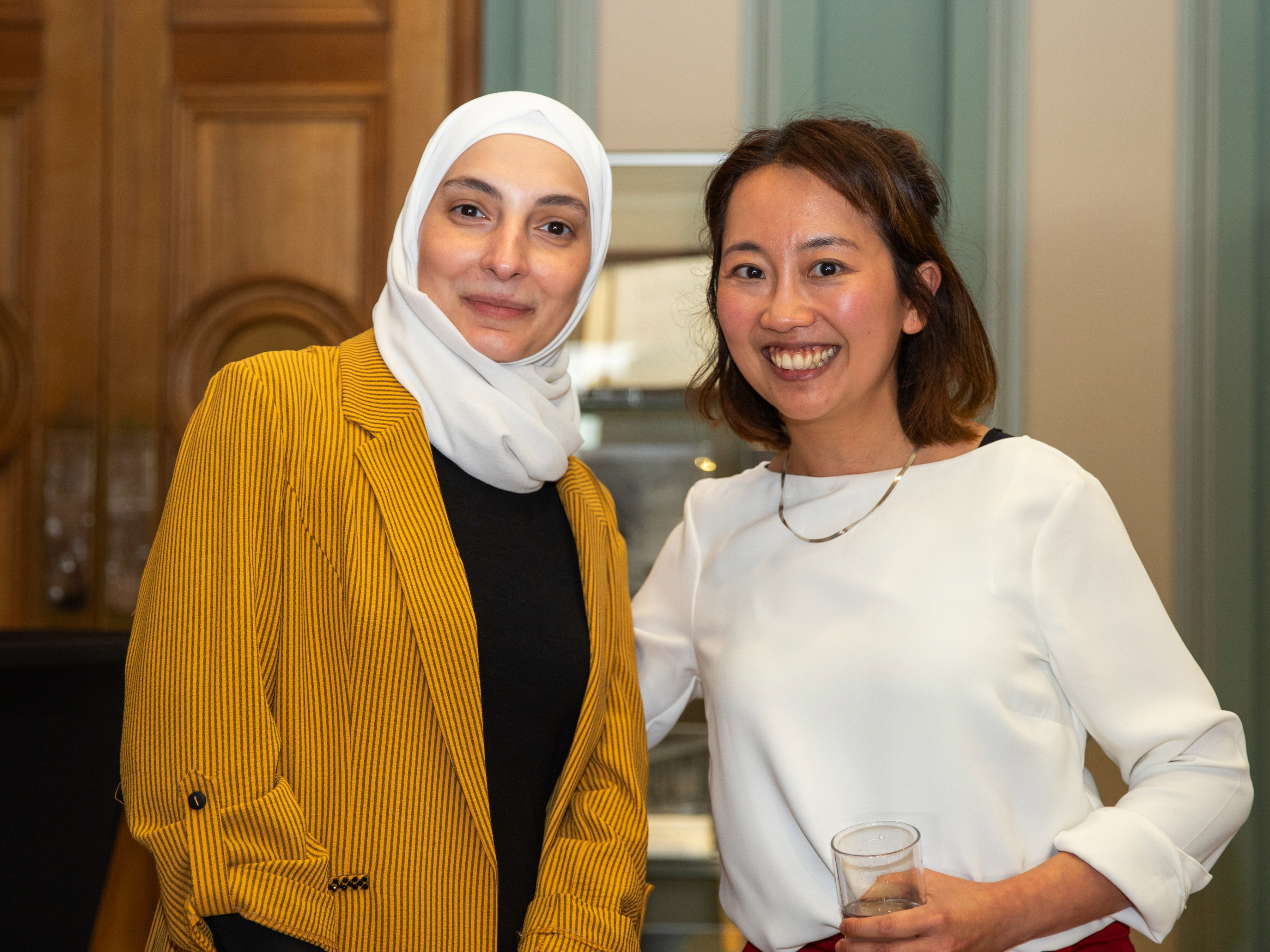 Furat Al Yafi and Freda Tait stand side by side and smile in Burlington House