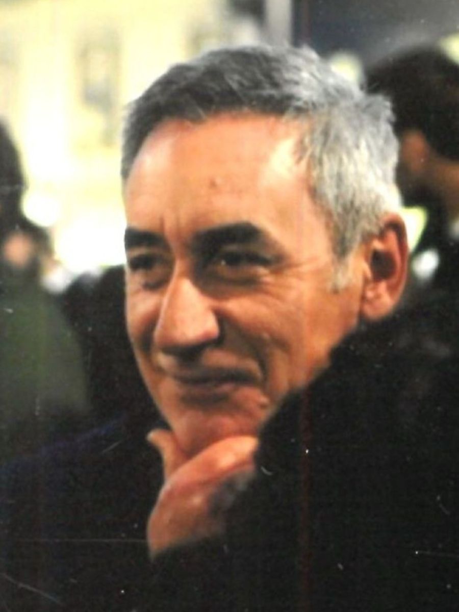 Giuseppe Graziano with his hand on his chin in black coat looking away from camera