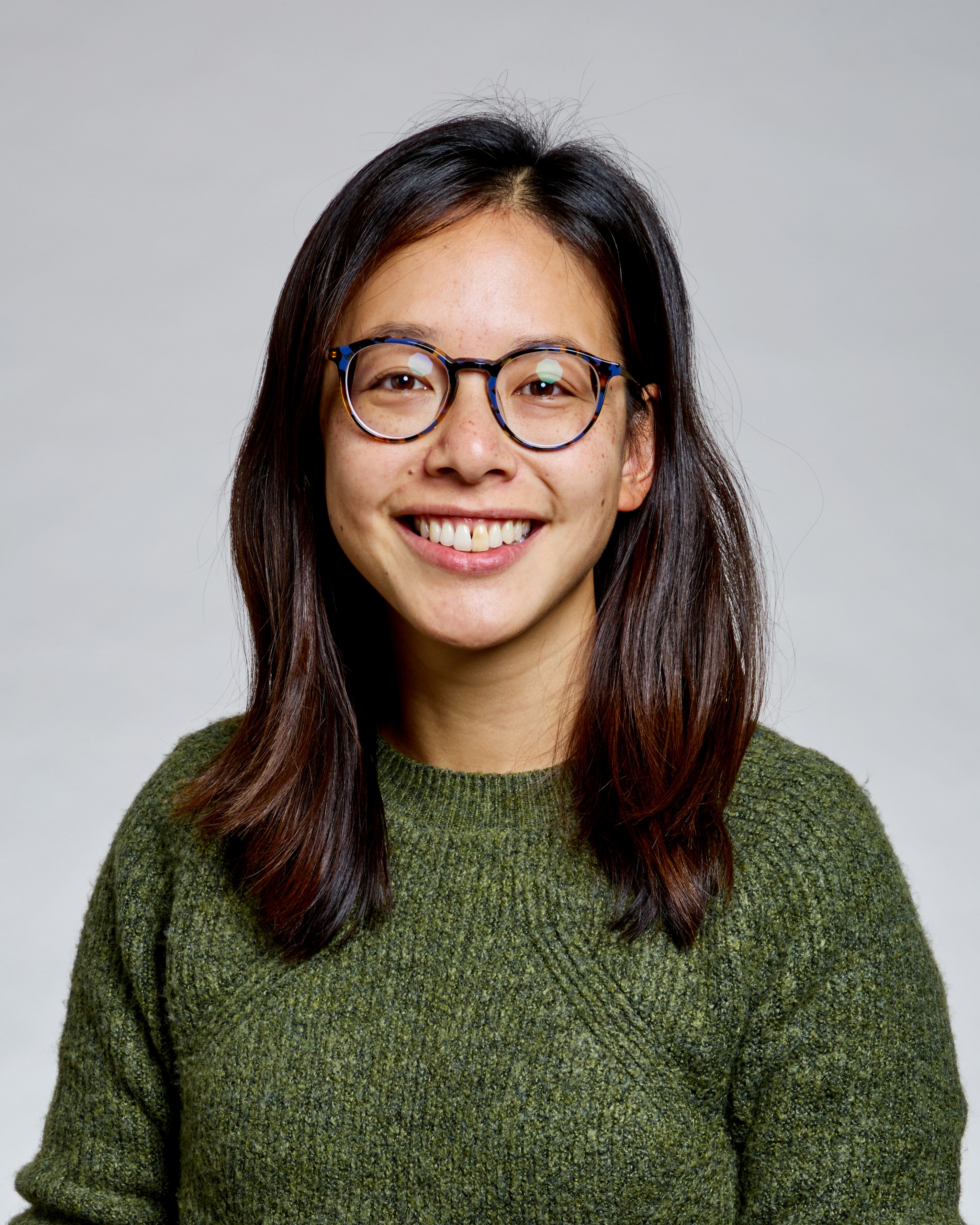 a woman wearing glasses and smiling