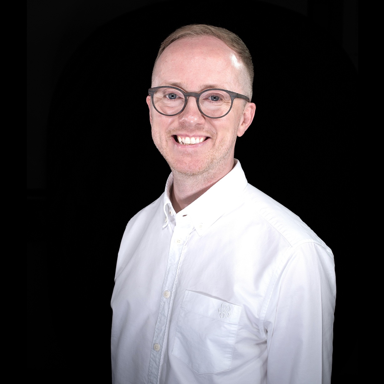 a man wearing glasses and a white shirt