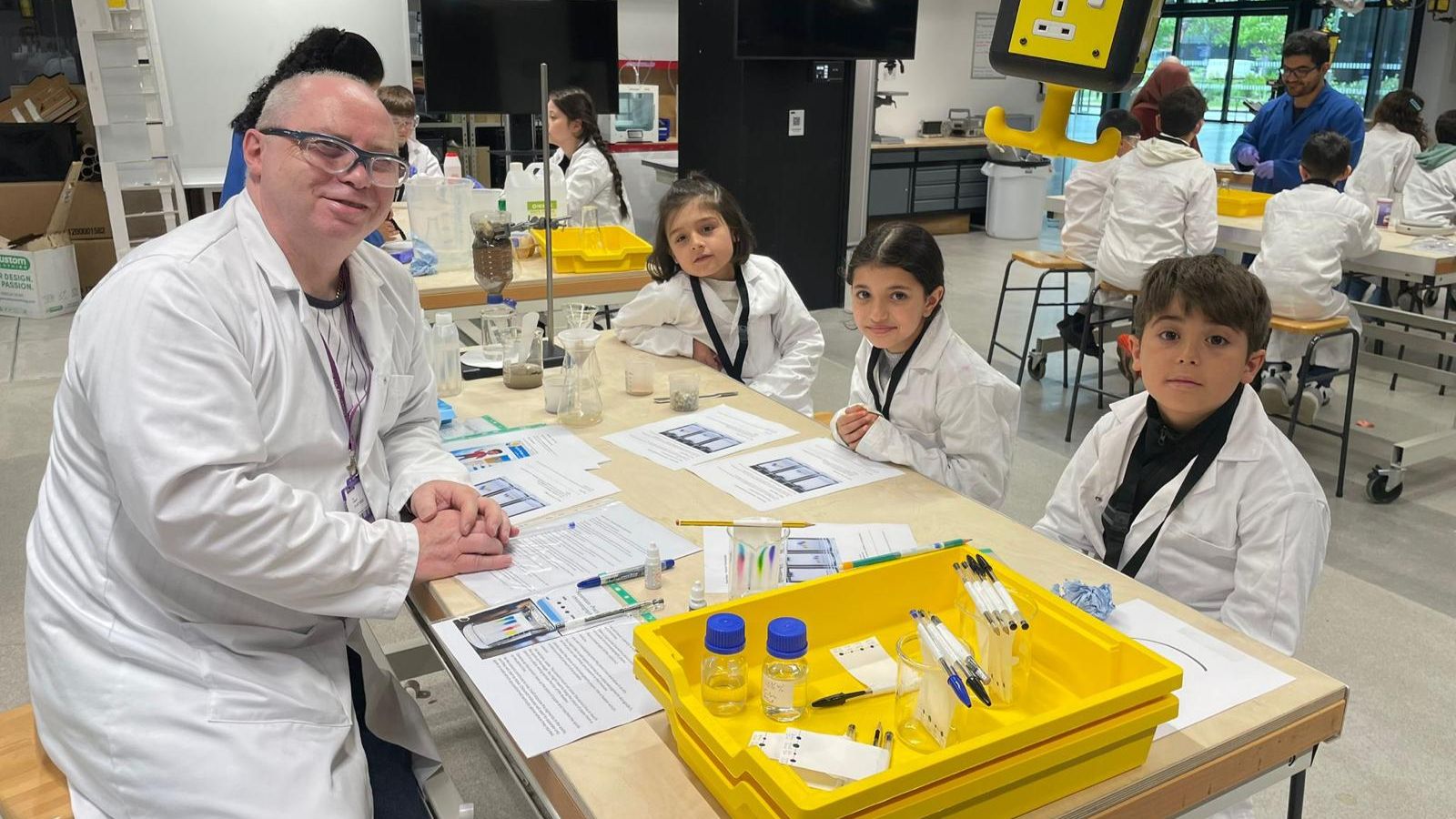 Syrian refugee school children at chemistry workshop with volunteer