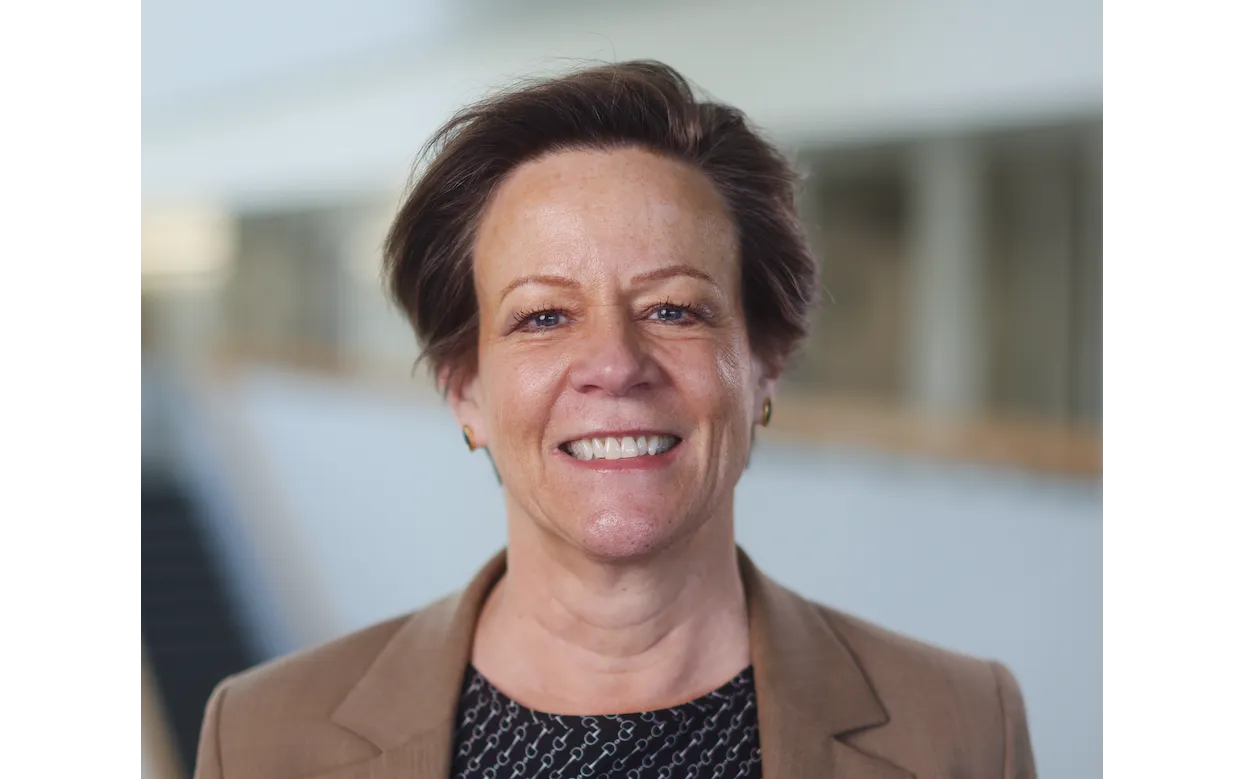 Professor Donna Blackmond in brown suit jacket smiling at camera