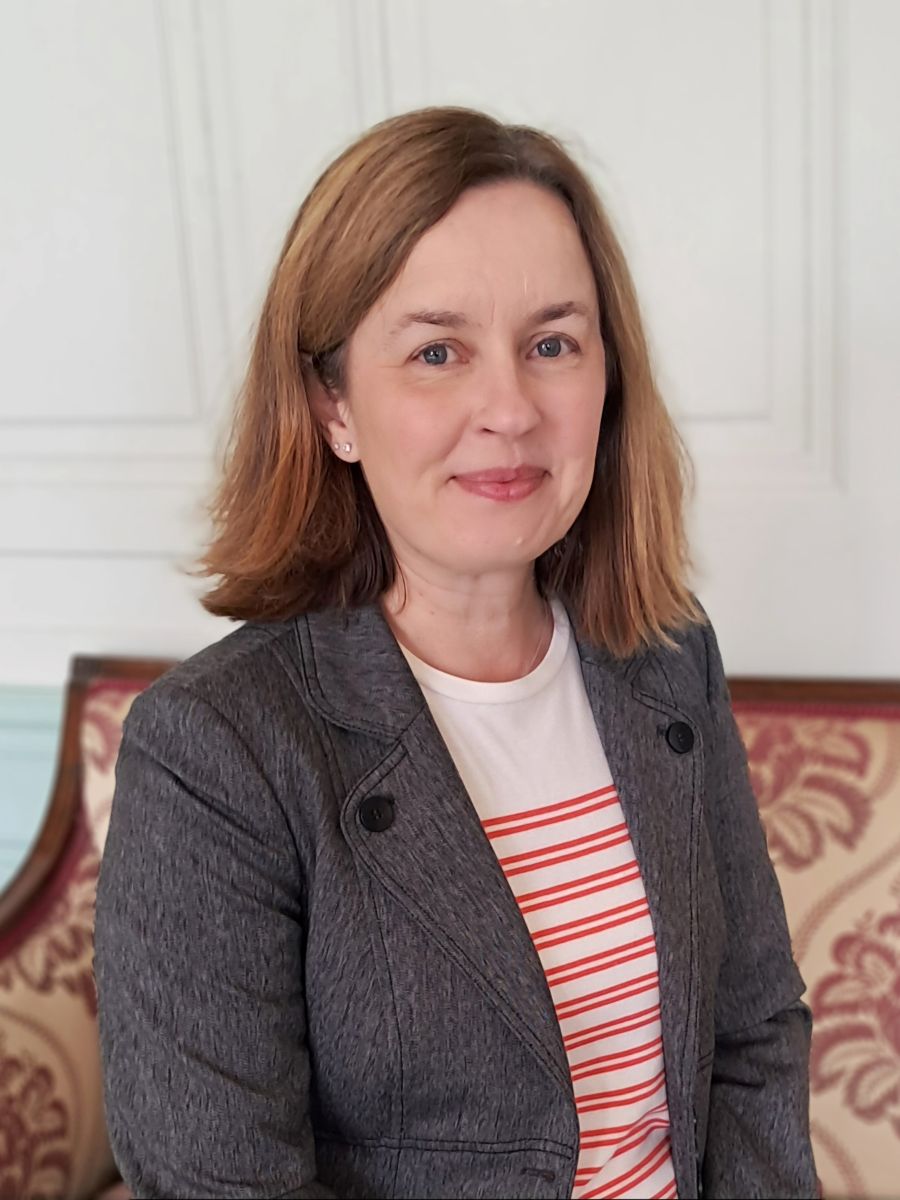 Jenny Boxwell smiling at camera in grey suit jacket and white top