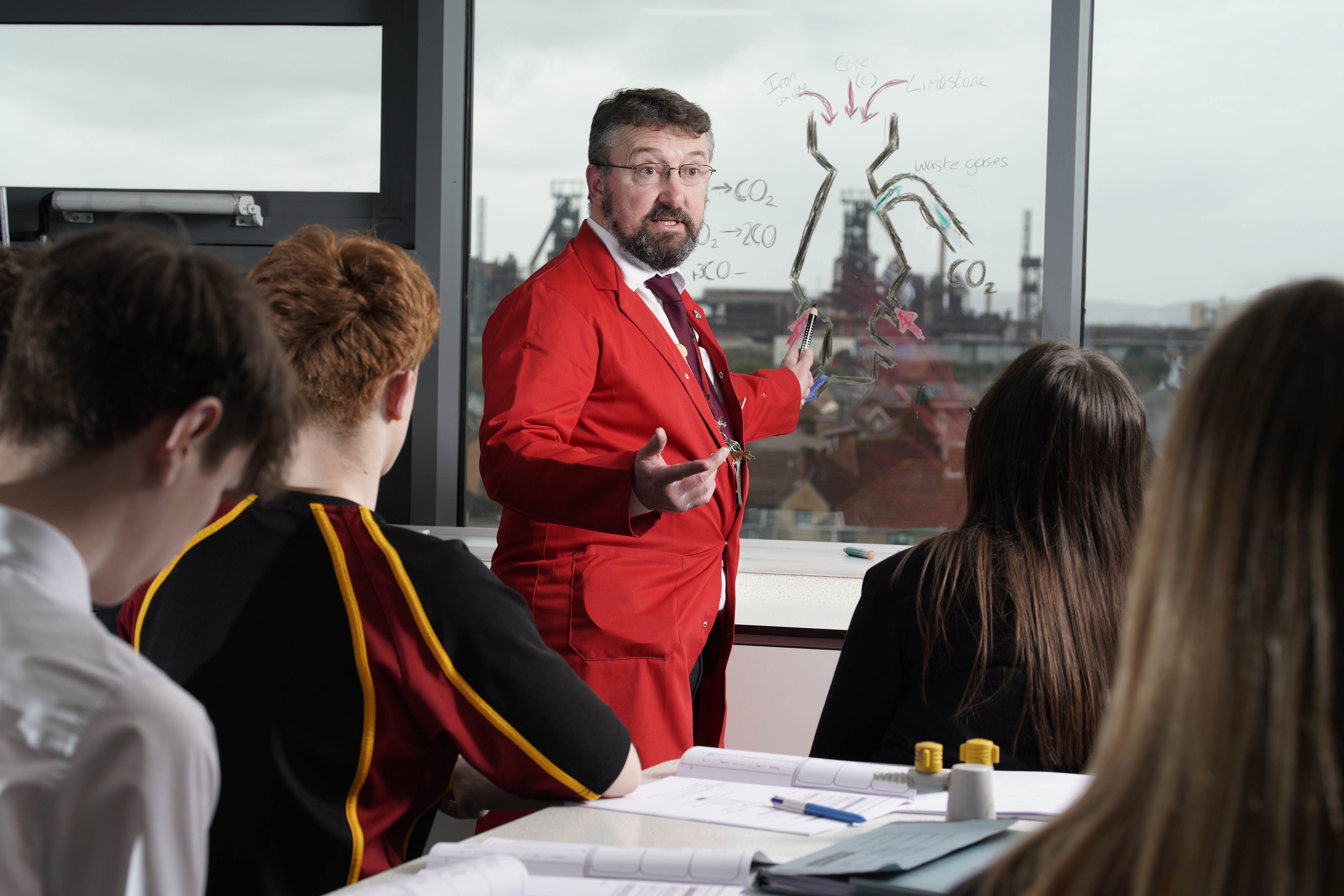 Eurig Thomas, Deputy Head Teacher at Ysgol Cwm Brombil High School in Port Talbot, wearing a red suit teaching a class