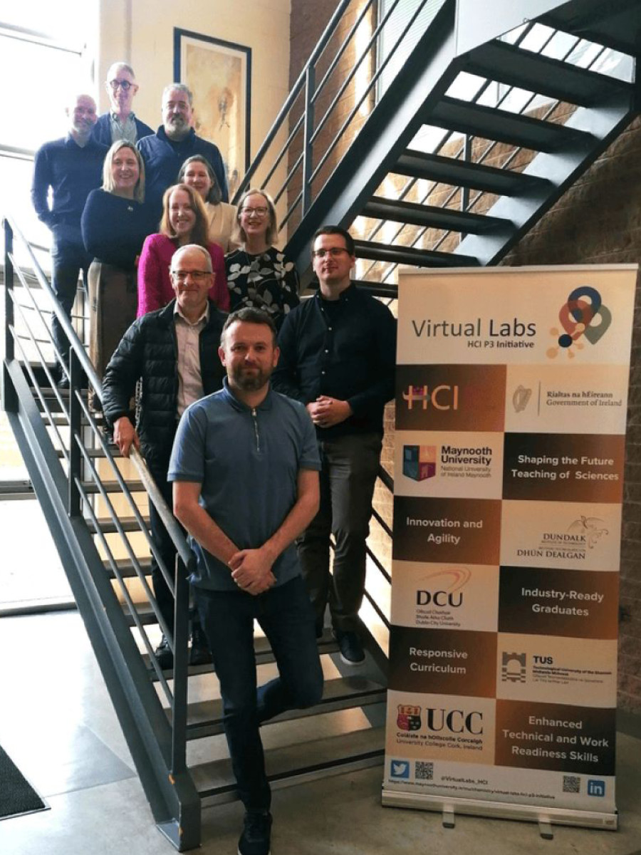 Virtual Labs Team standing on various steps of metal stair case