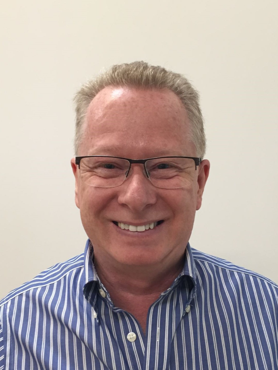 Roger Gough smiling to camera in blue striped shirt