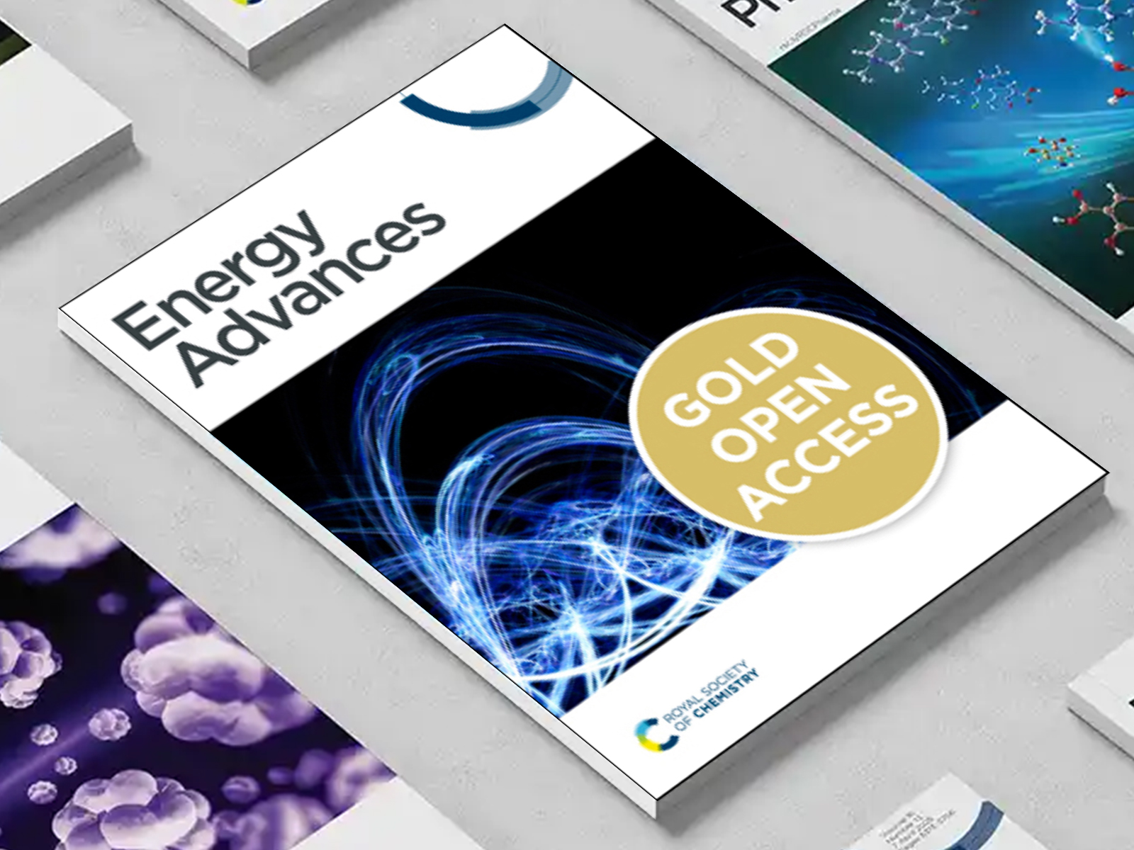 the Energy Advances journal among a group of other journals on a desk
