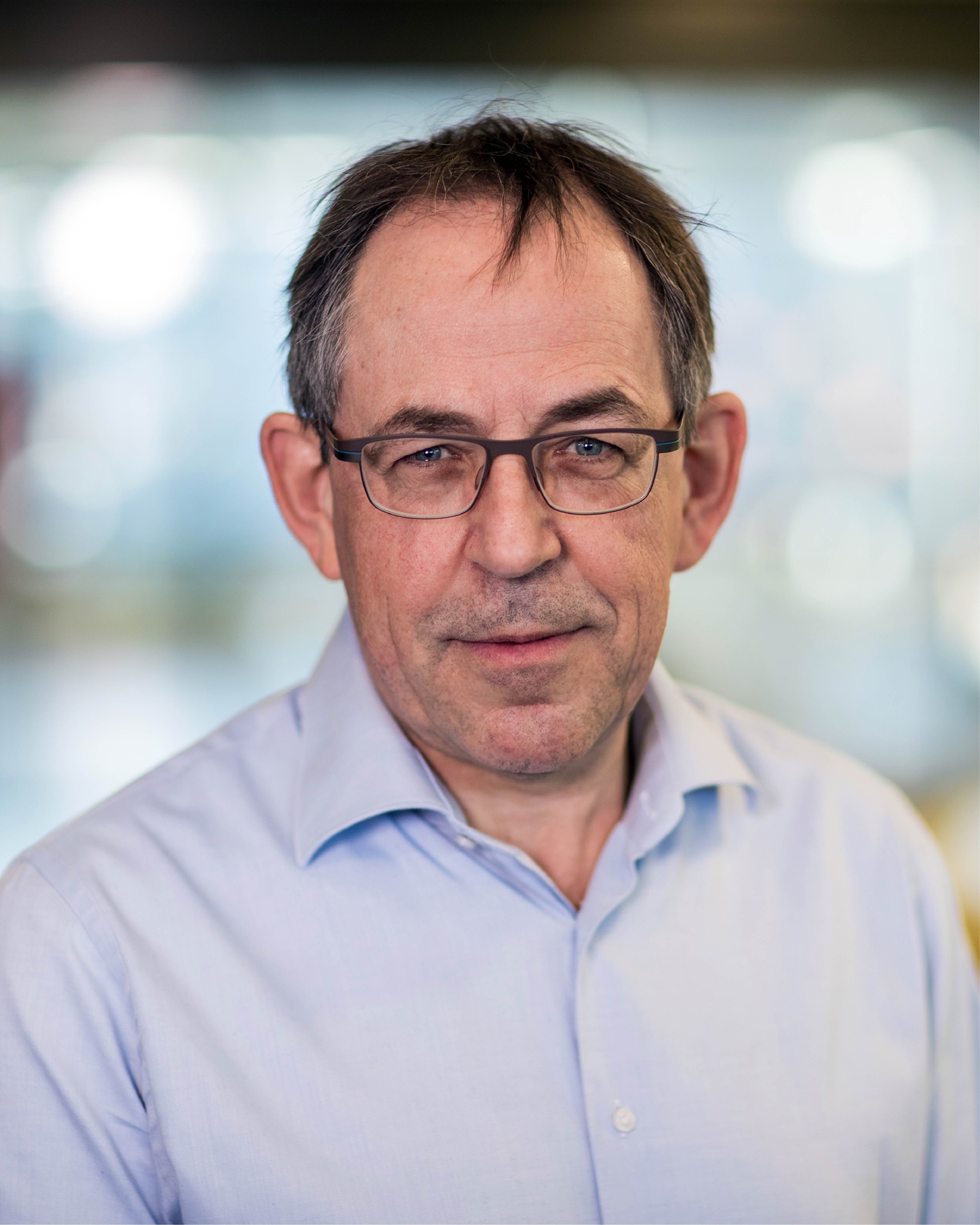 René Janssen looking at the camera wearing glasses and a blue polo shirt