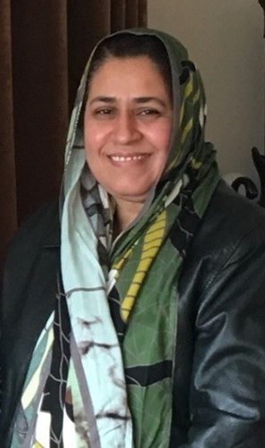 Portrait of Naveed Kausar Janjua, smiling with a green scarf covering her head 