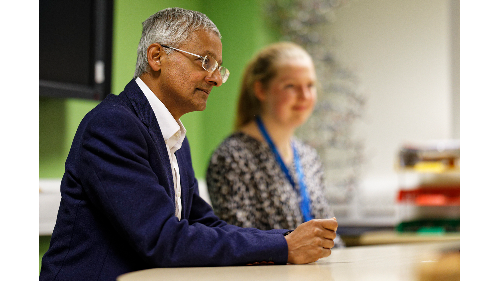 Professor Sir Shankar Balasubramanian at a table at meeting with others