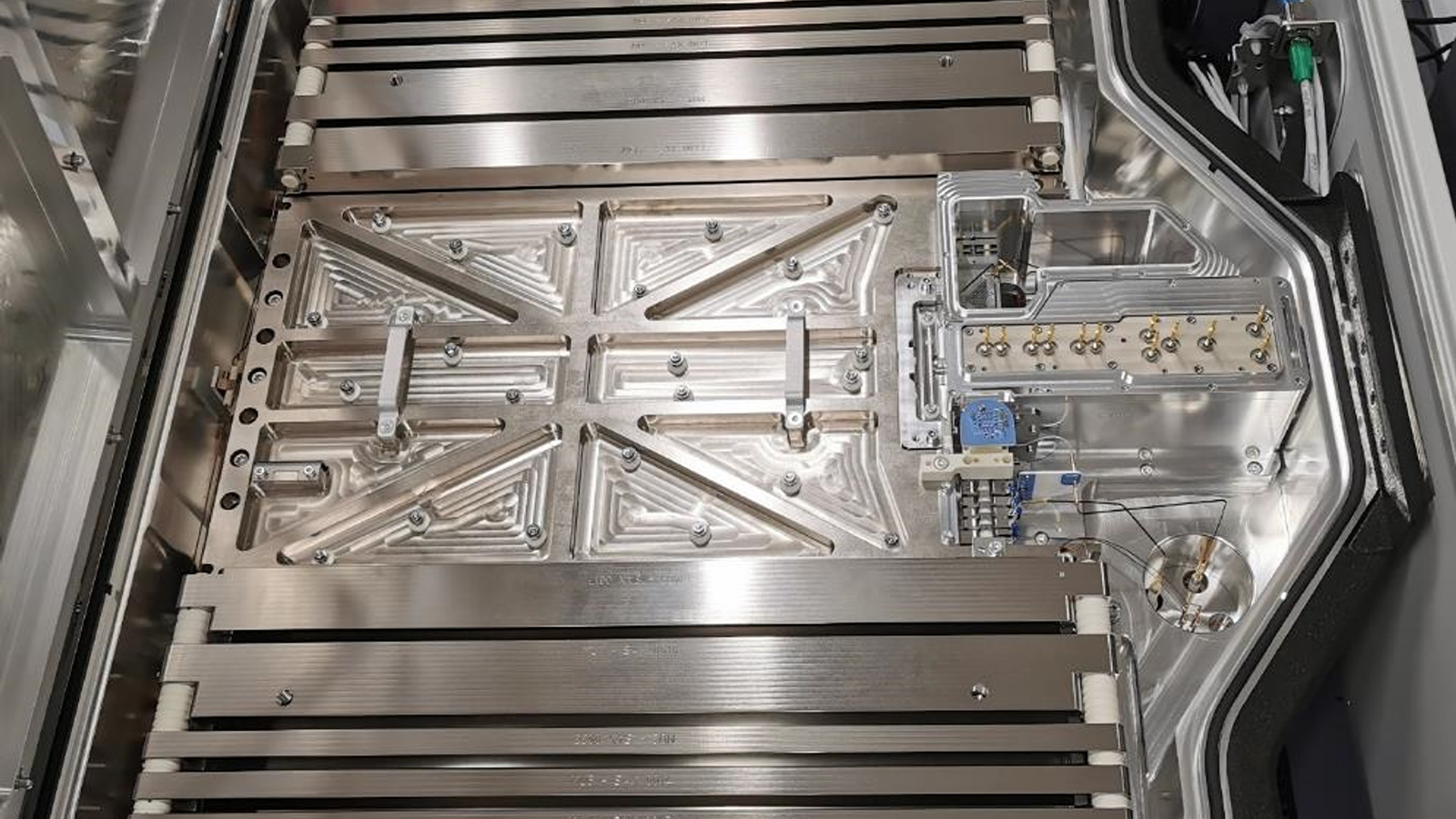 A metal surface with many metal parts at the Orbitrap Astral Team lab
