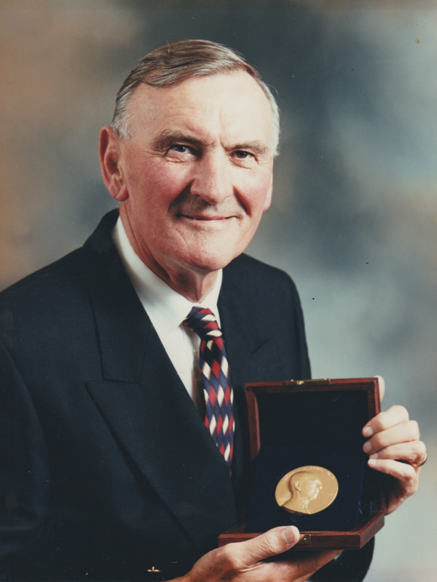 John Lewis in suit and tie holding award medal