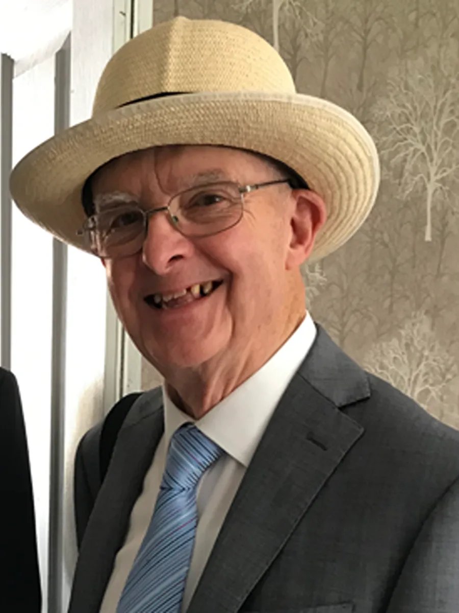 John Hodgson deceased John Hodgson smiling to camera in hat, glasses, suit and tie