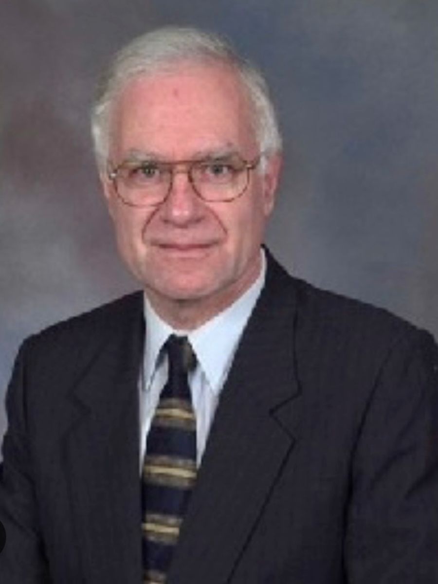 Clive Hamlin smiling to camera in dark suit, shirt and tie