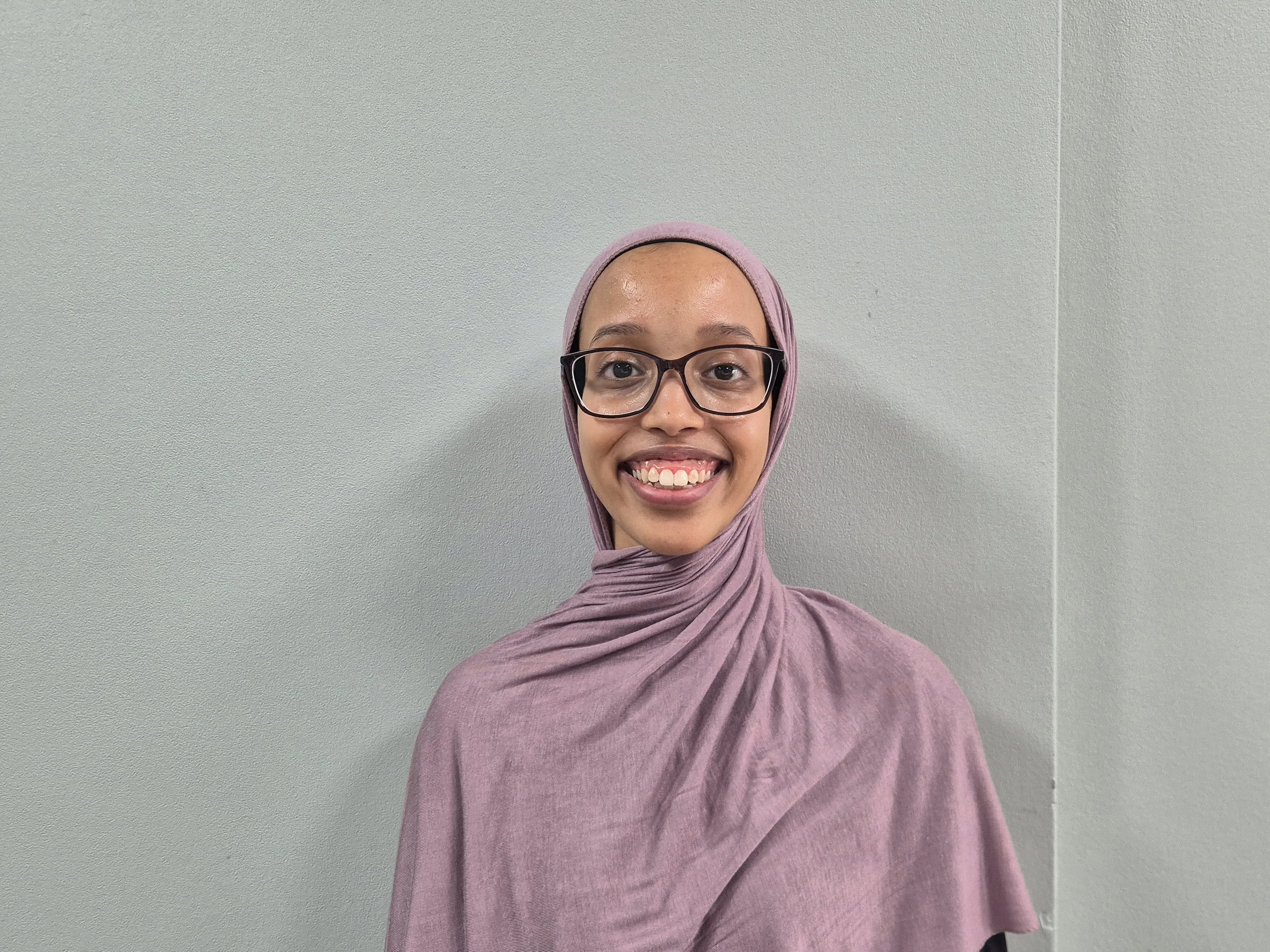 Broadening Horizons 5 - Amal Yussuf a woman wearing glasses and a scarf