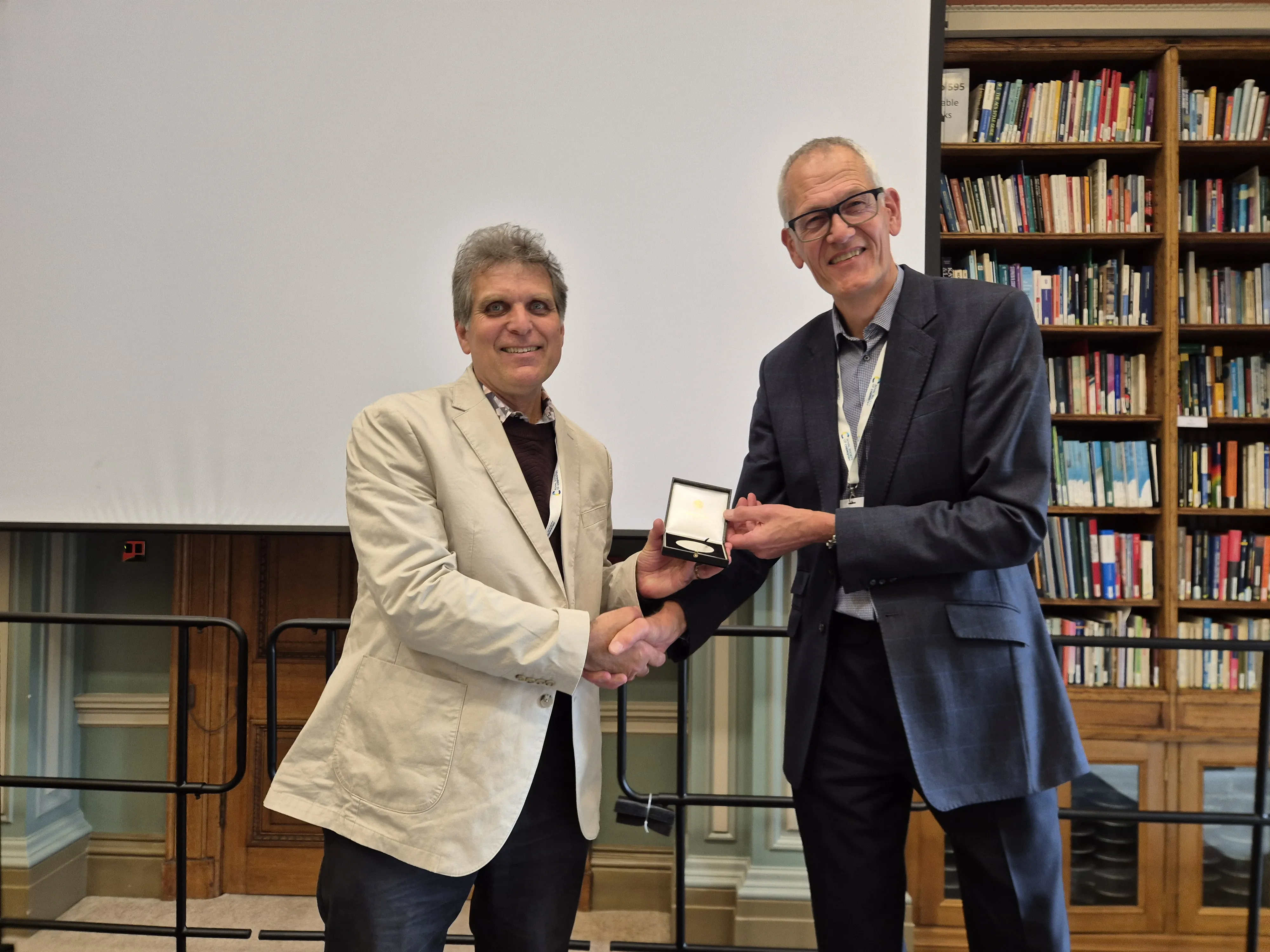 2026 Chemical Biology Symposium - Professor Mark Bradley and Dr David Andrews Professor Mark Bradley (left) receives his CBIC Presidential Medal and shakes hands with Dr David Andrews