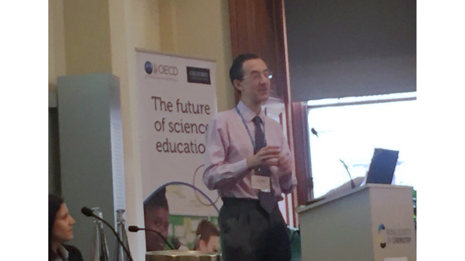 Dr James Redman presenting, standing at a podium