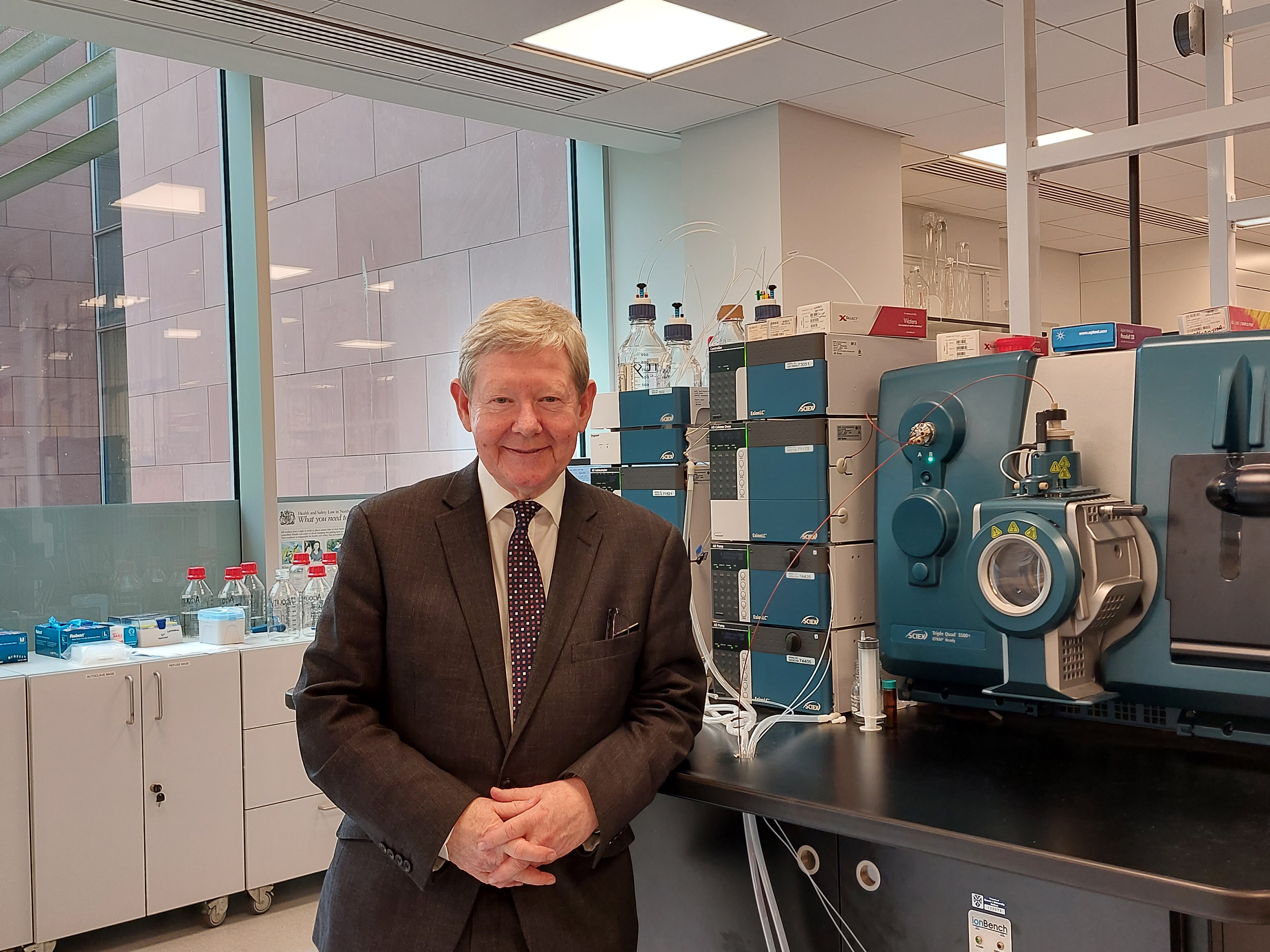a man in a suit standing in front of a table with equipment