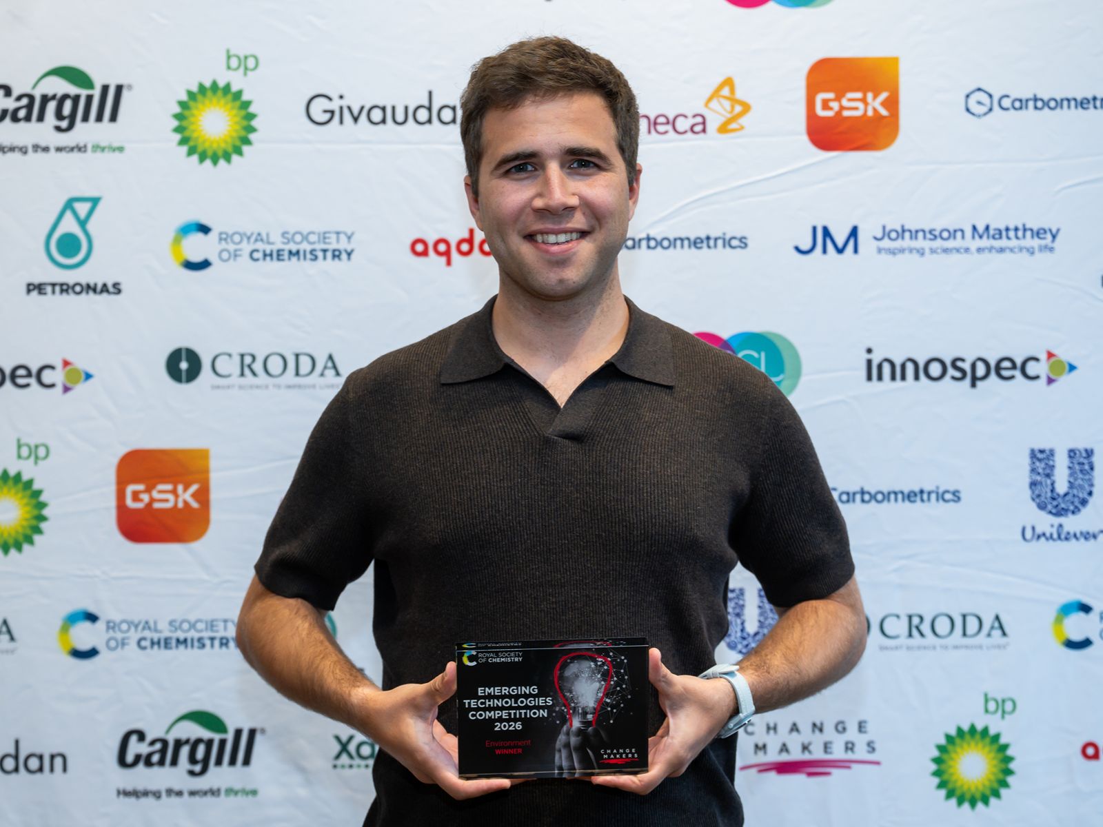 Emerging Technologies Competition - Rayan (1) Rayan Osseiran, Demeter Bio co-founder and CEO, smiles and holds a plaque