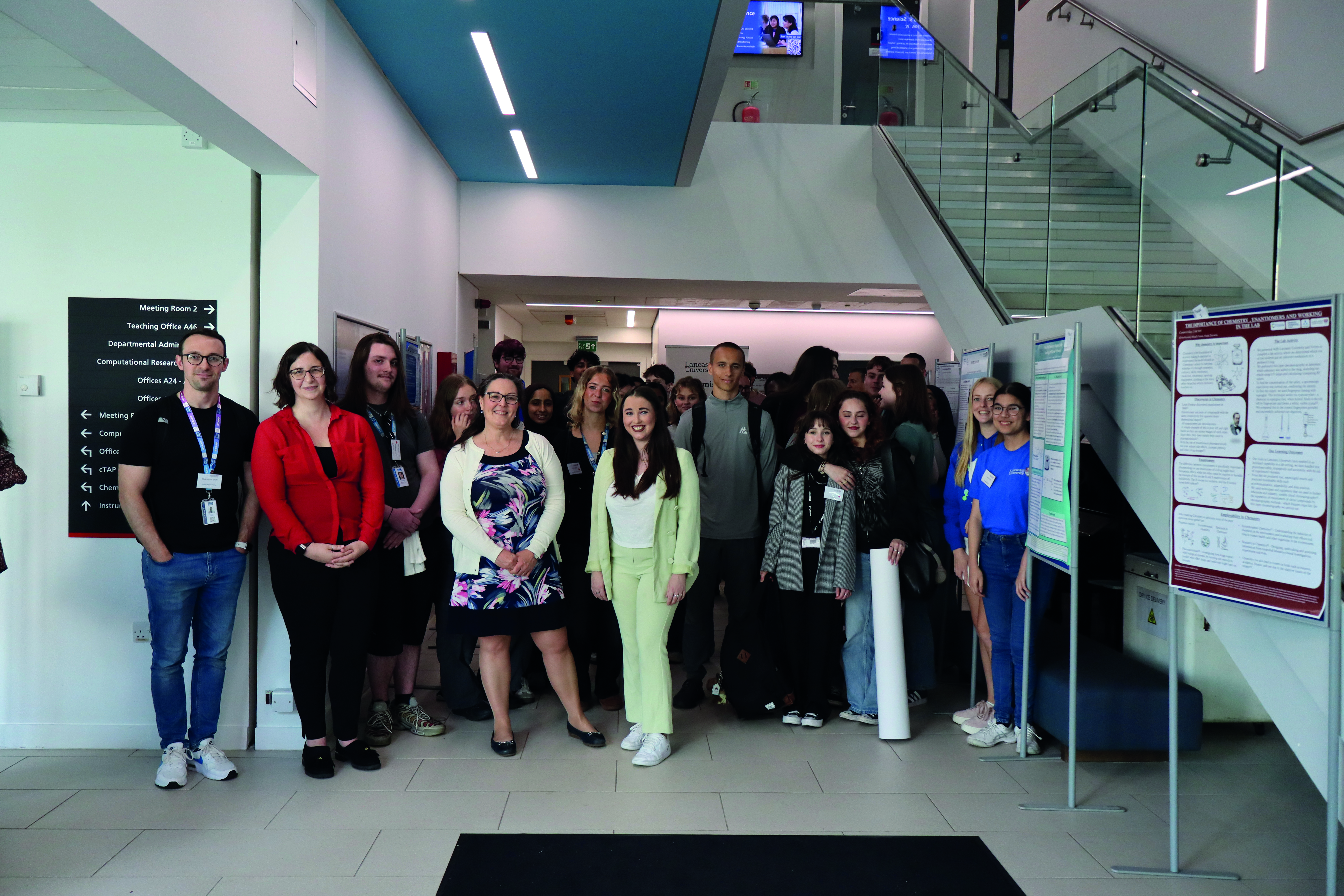 Dozens of students stand together in a university building
