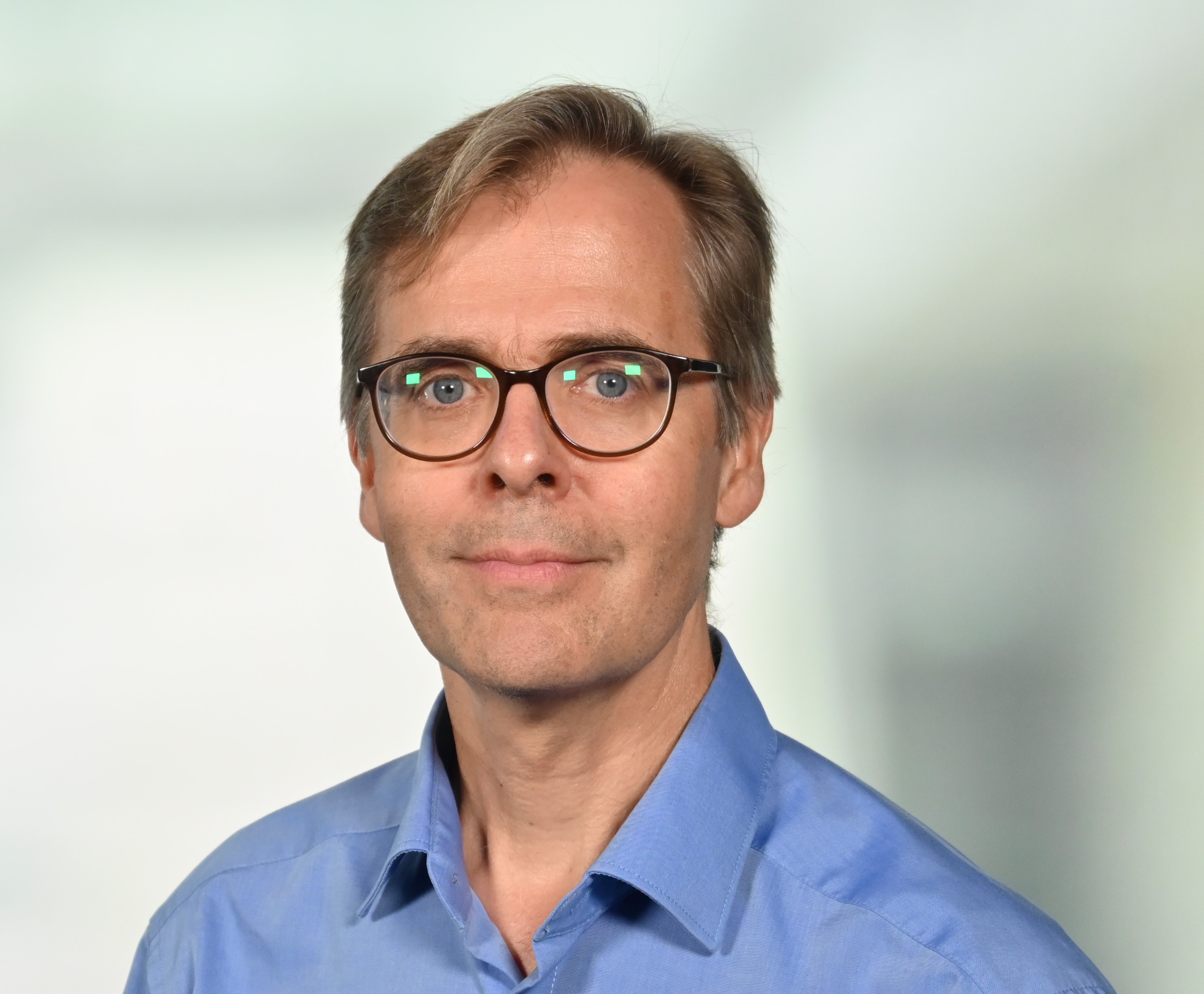 a man wearing glasses and a blue shirt