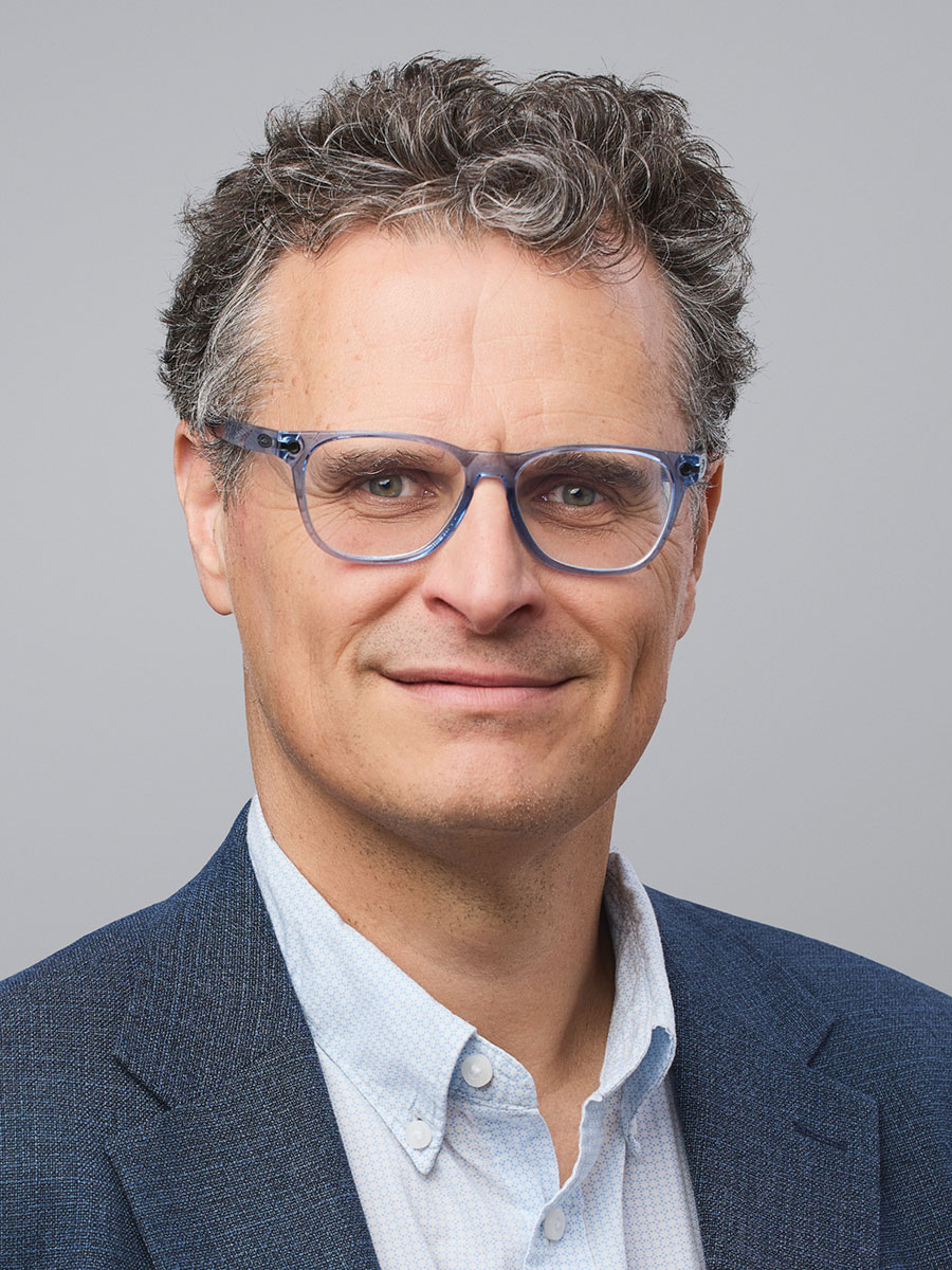Javier Perez-Ramirez smiling to camera wearing glasses, blue shirt and dark blue suit jacket