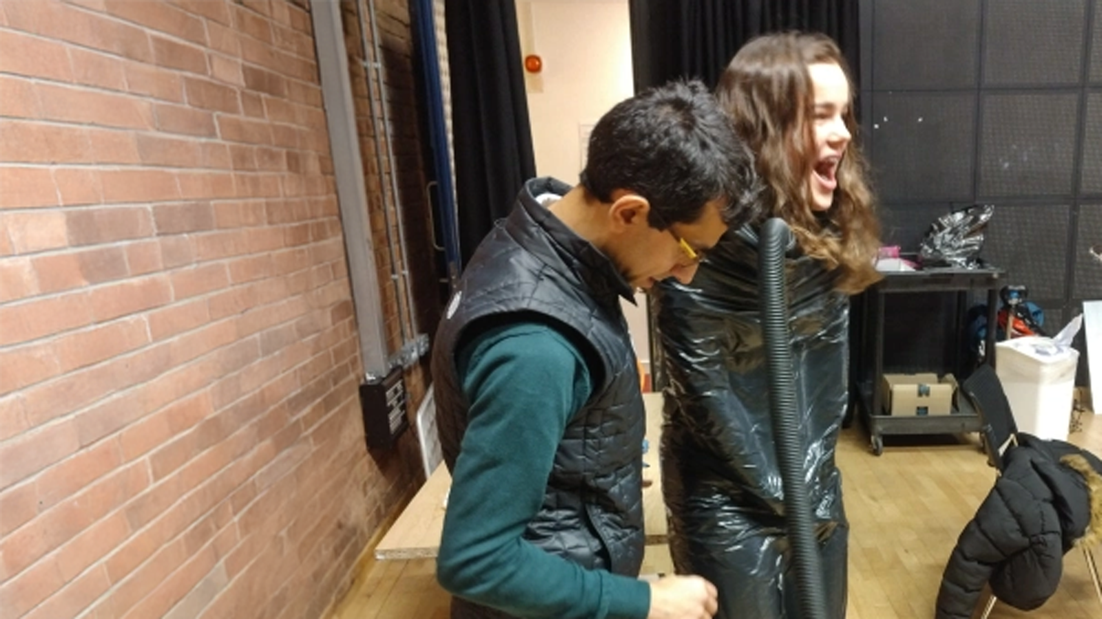 The BoostCrop team demonstrating some of there research by using a Henry hoover to suck the air out of binliner wrapped around a child!