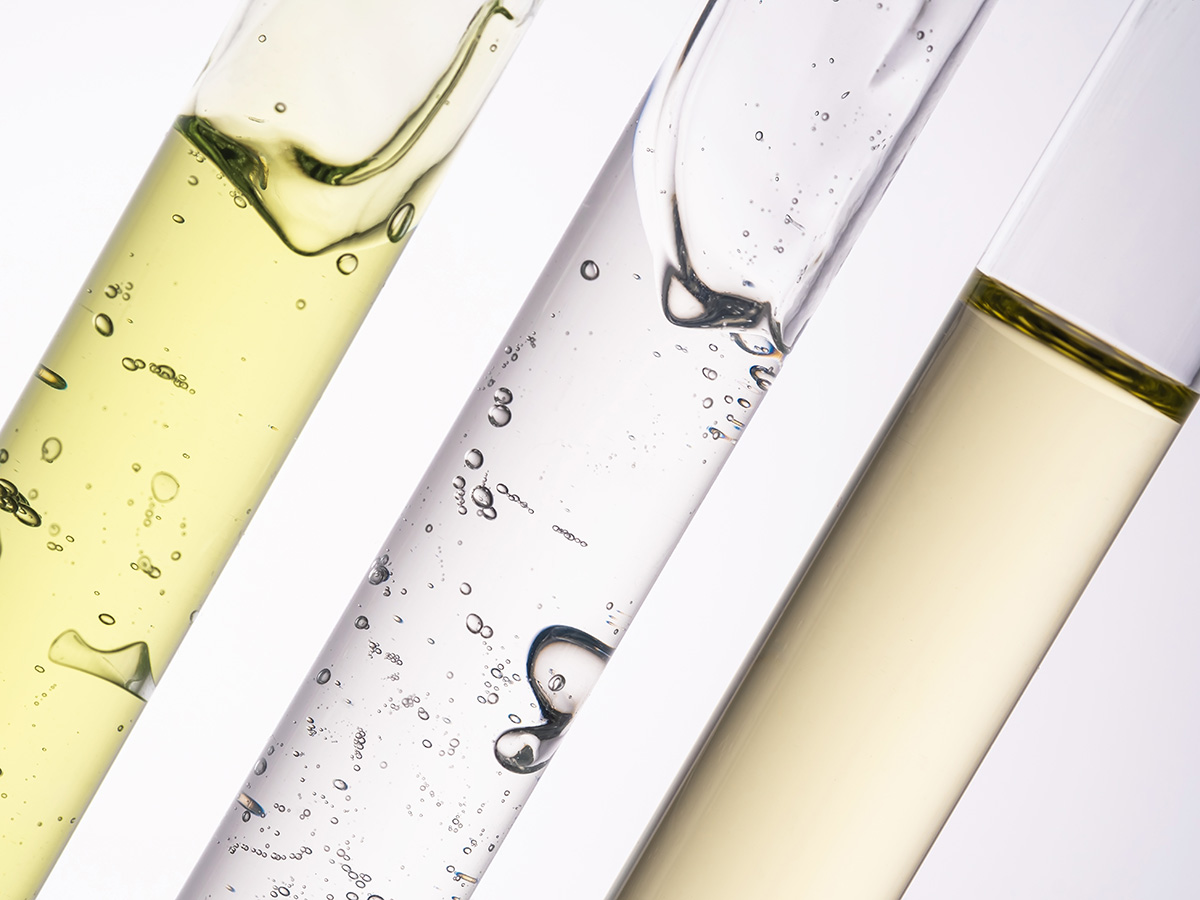 Three test tubes, one containing green gel, clear gel and oil