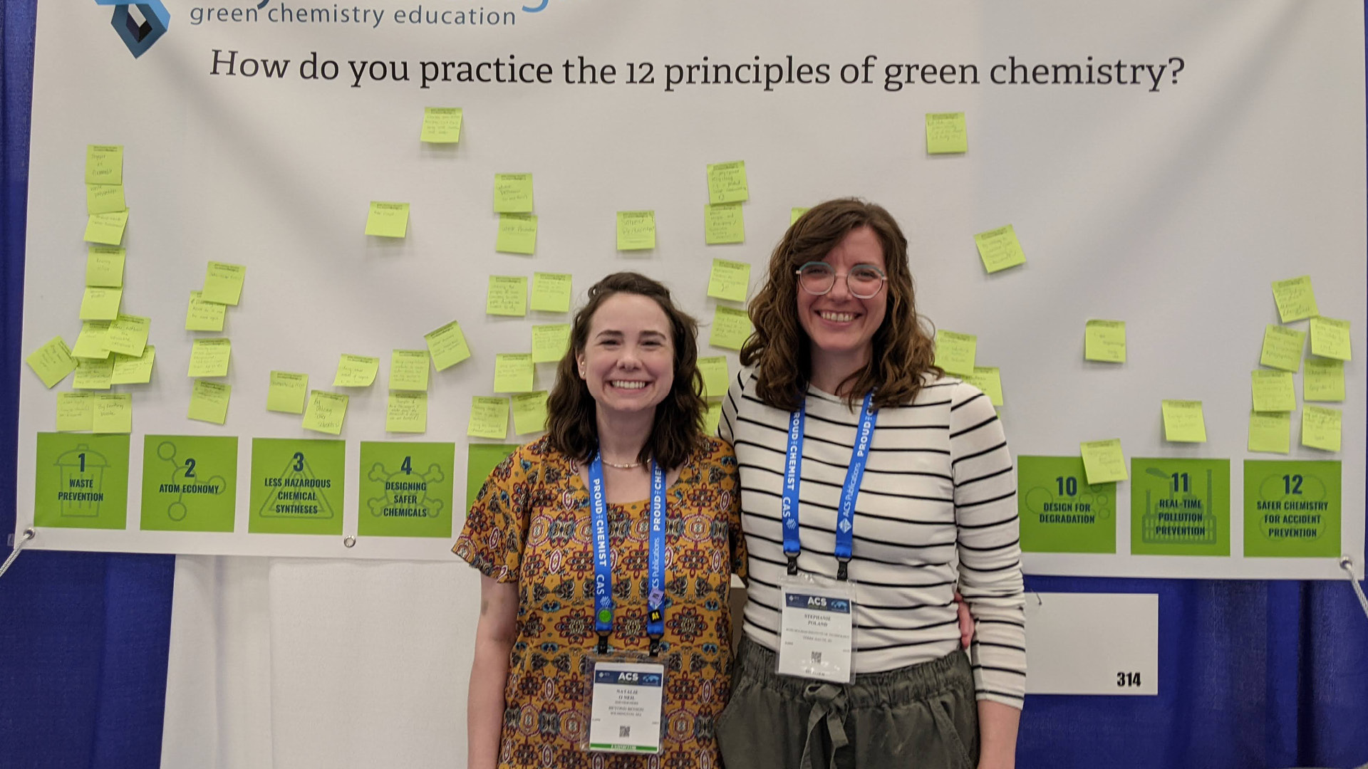Two of The Green Chemistry Commitment in front of large area of paper containing large amount of post-its
