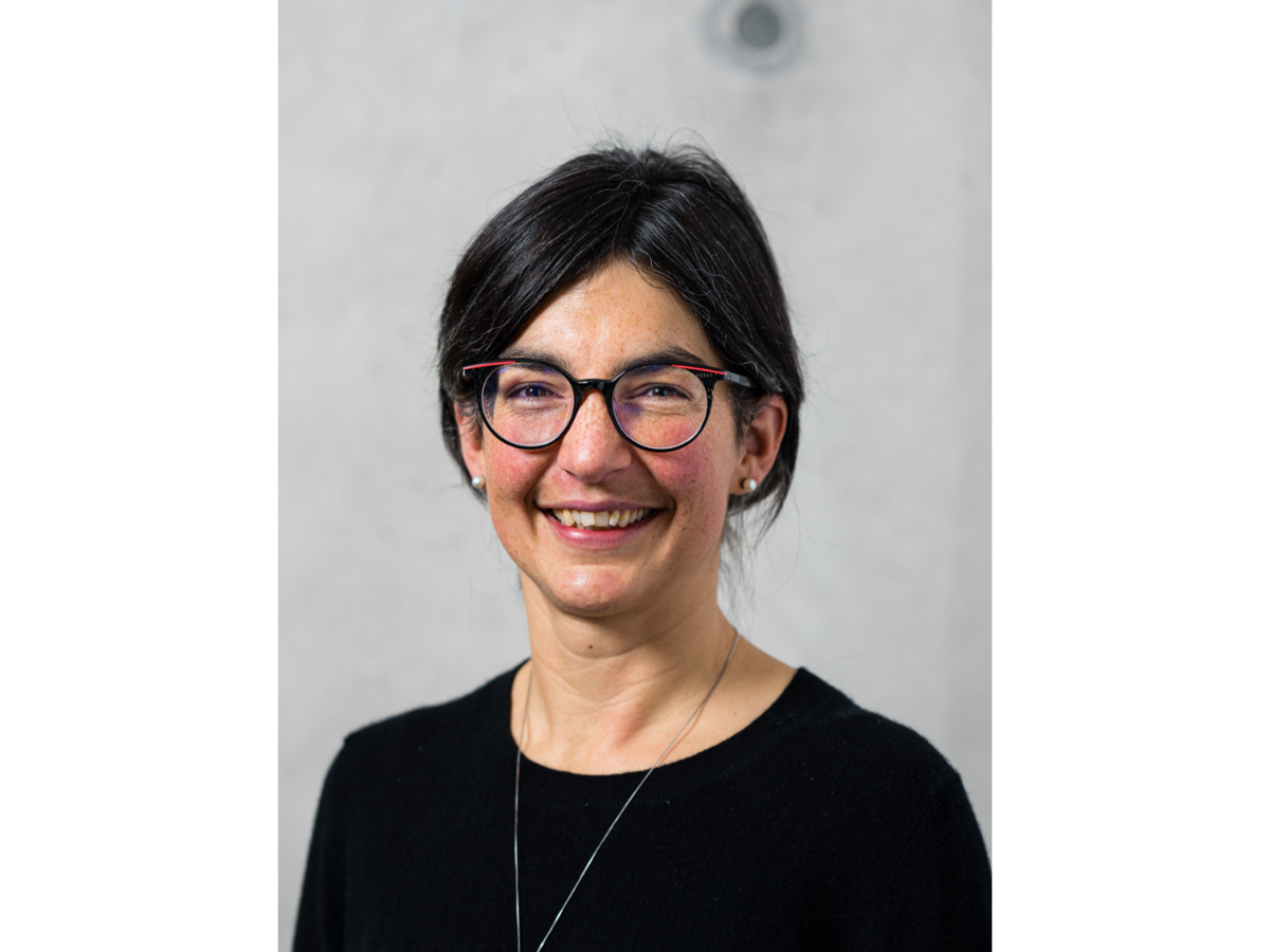 Anna Hirsch wearing glasses and smiling to camera