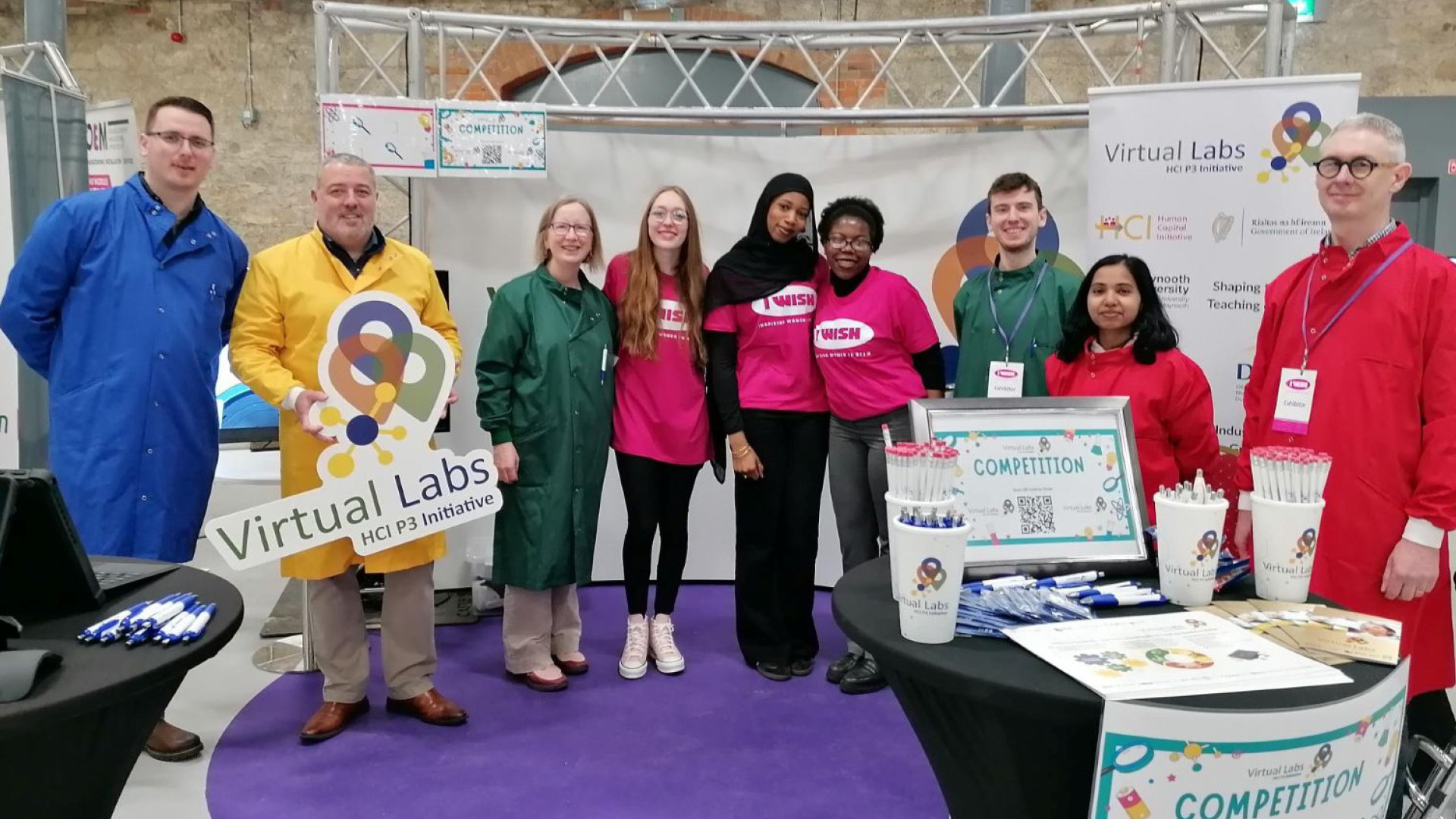 Virtual Labs Team in colourful lab coats at a stand