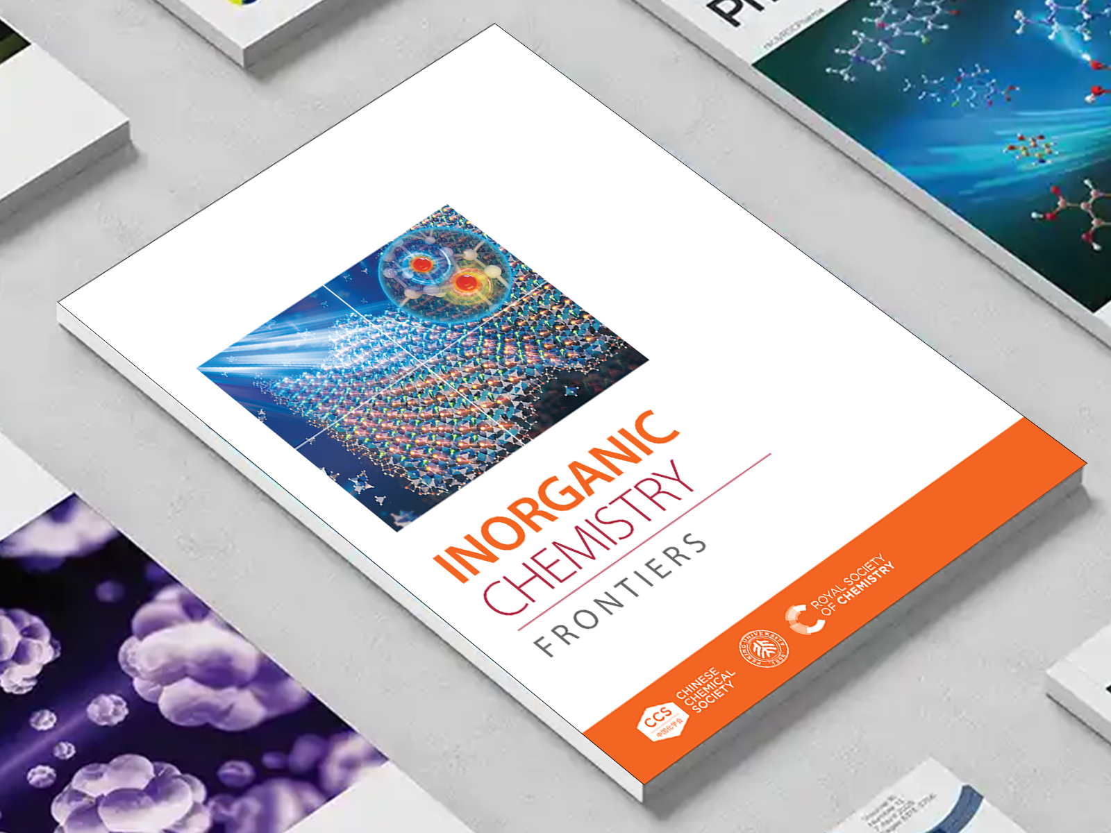 the Inorganic Chemistry Frontiers journal among a group of other journals on a desk