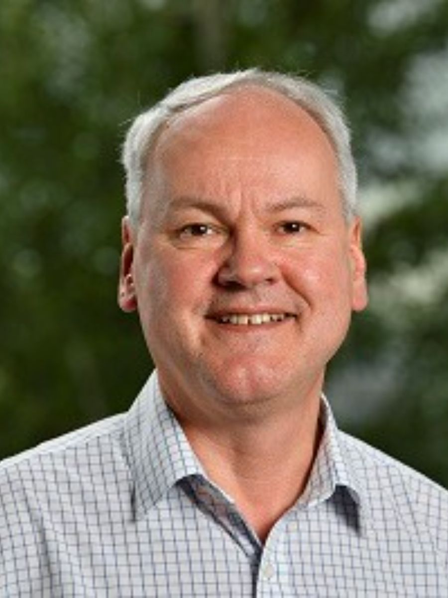 Jeremy Shears smiling for a picture in check shirt