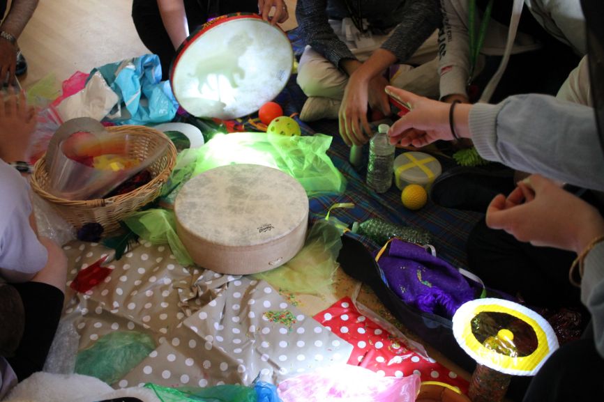 A finger points at a shadow art next to a table covered in materials