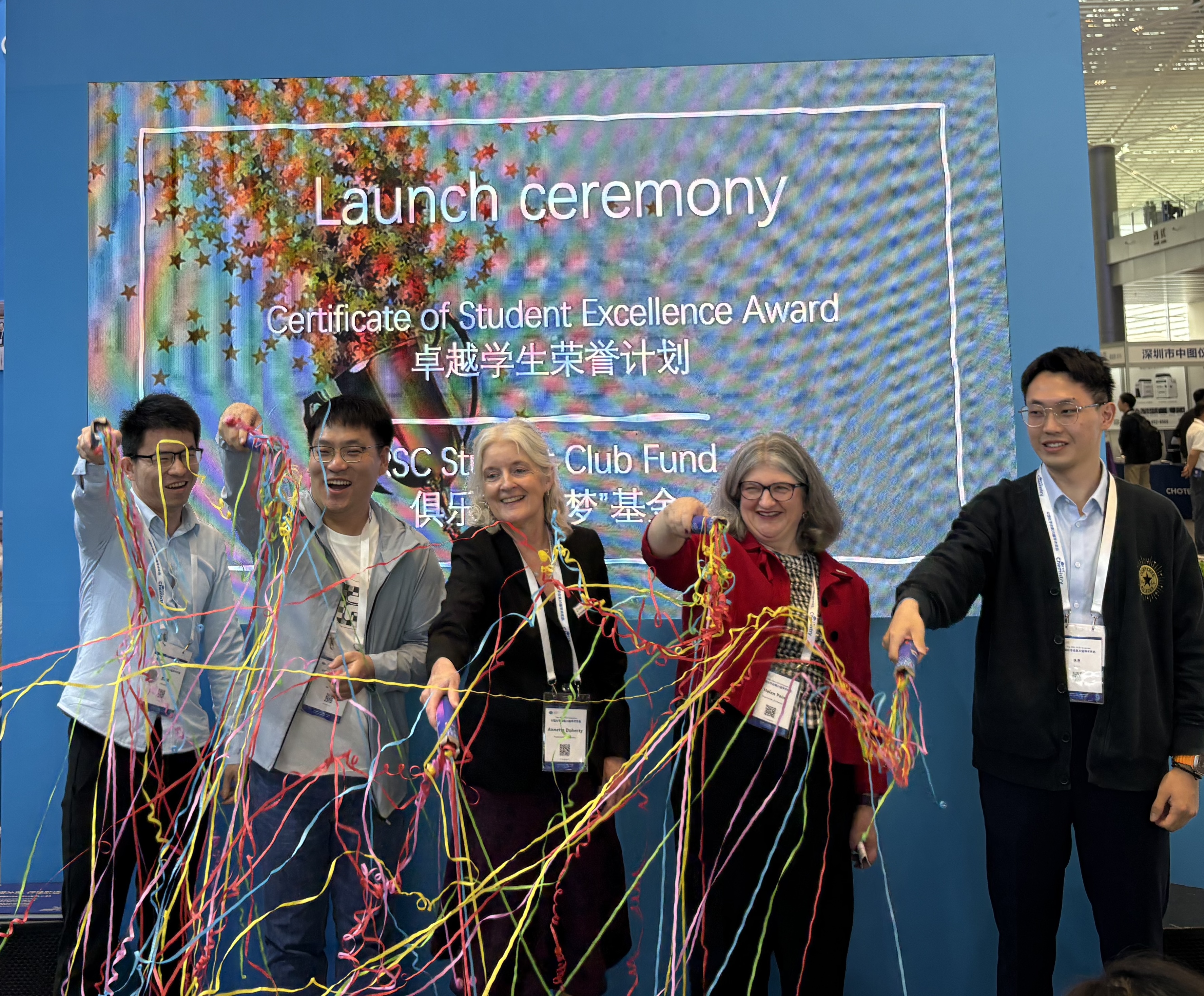 Student Award and Fund - 1 (RSC in China 2026) Dr Annette Doherty (middle) and Dr Helen Pain (second right) wave colourful streamers alongside three other individuals at a launch ceremony in China