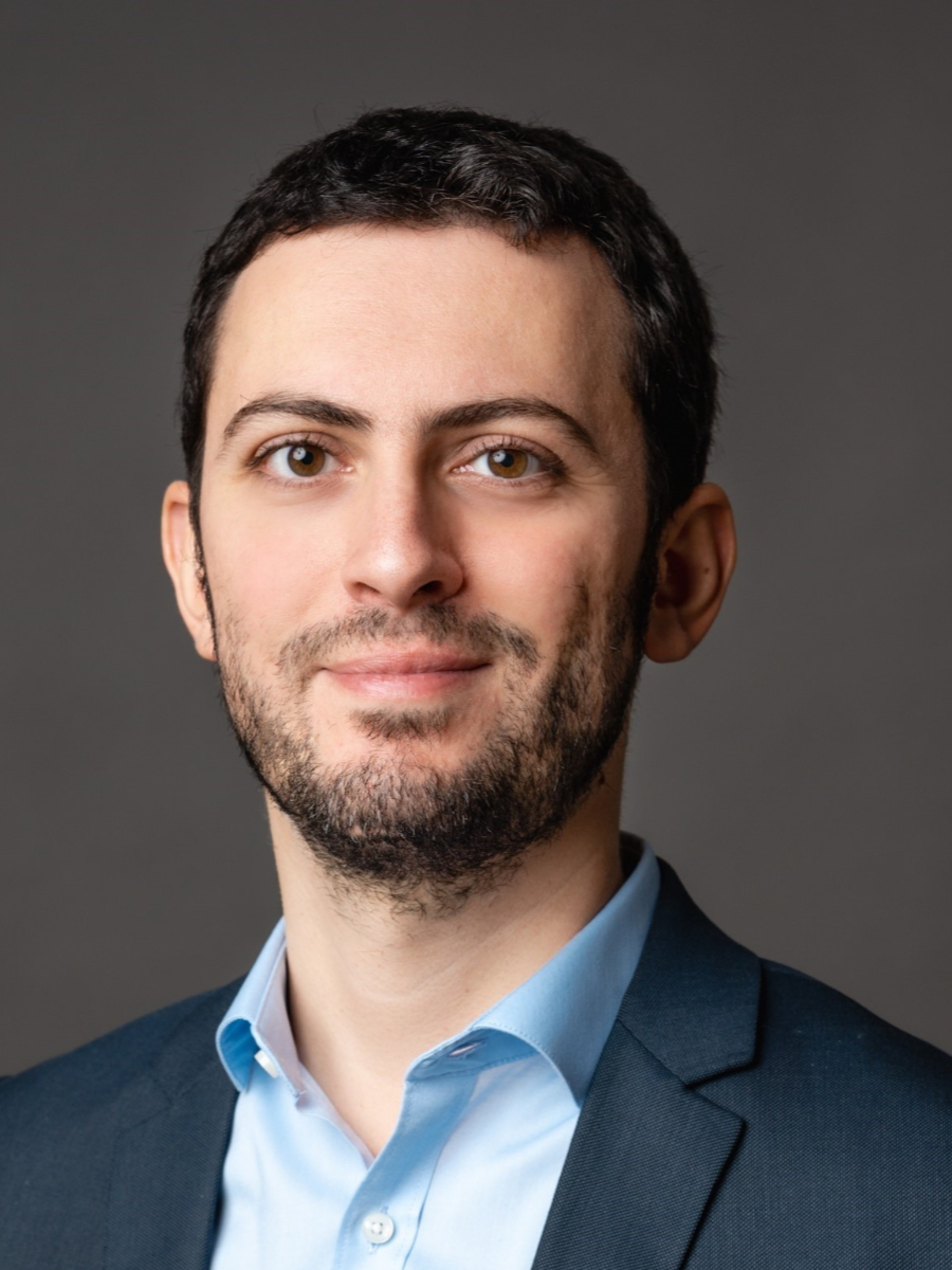 Gianvito Vilé wearing light blue shirt and suit jacket, with a beard and moustache