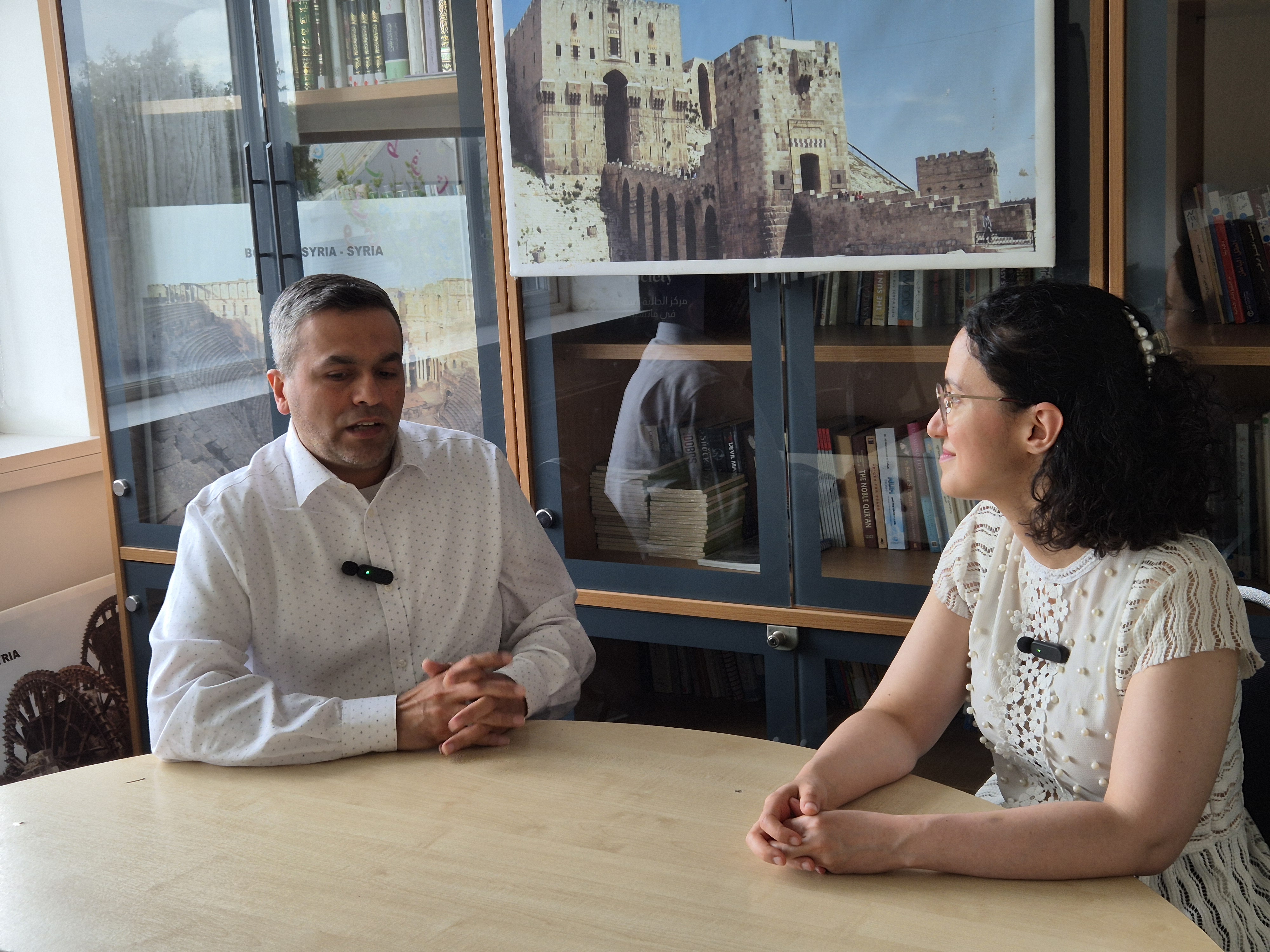 Abdullatif Alfutimie left Alaa Zam talking at a desk in a room at Burlington House