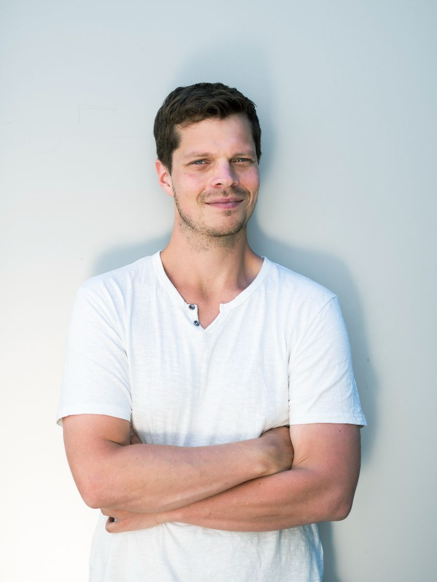 David smiling to camera in white t-shirt
