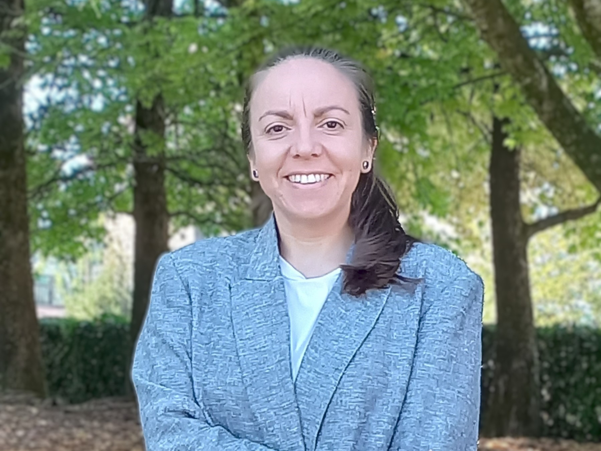 Beatriz Martín-García smiling to camera in blue jacket in woodland setting