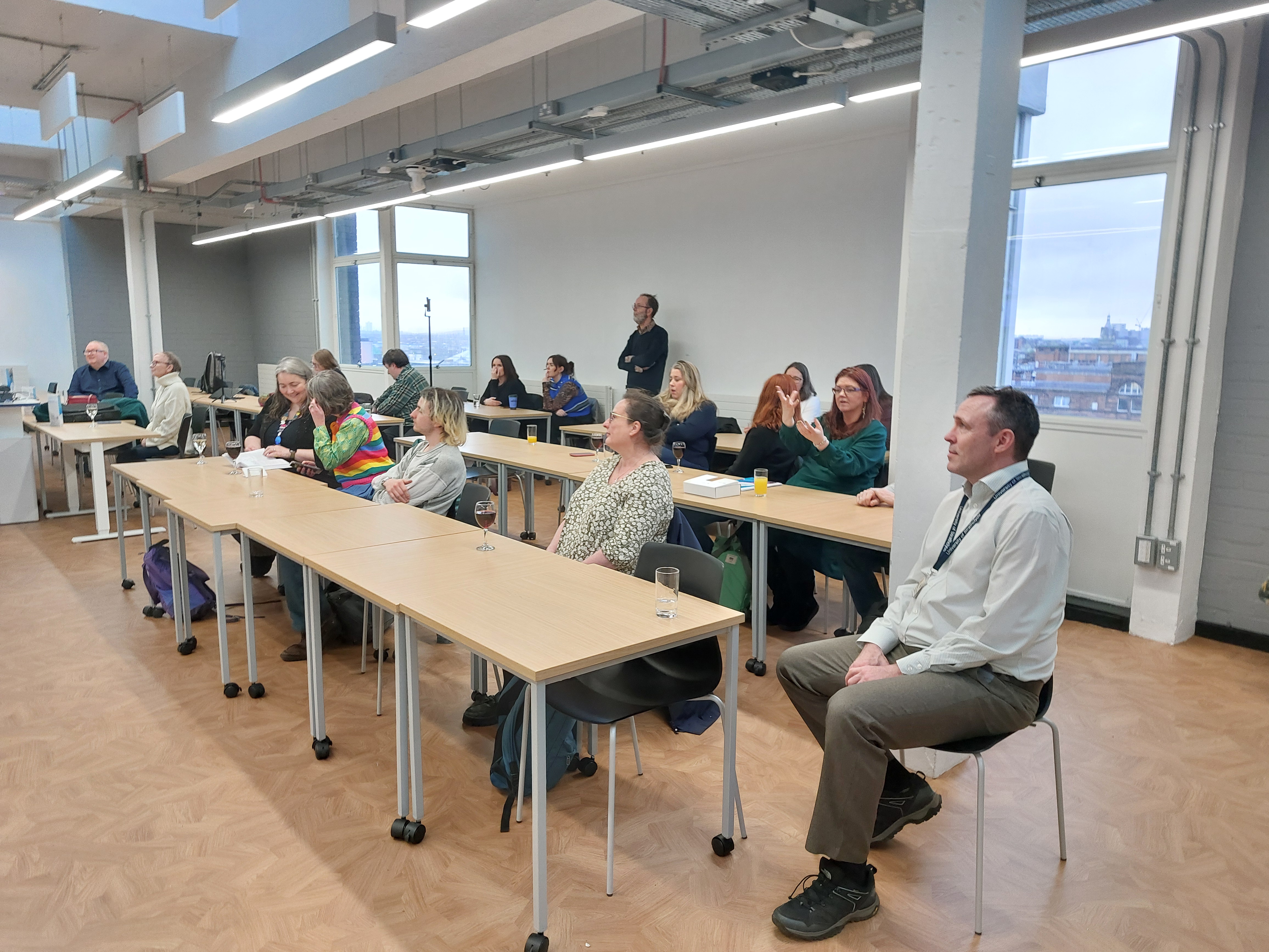 Attendees sit tables and watch the presentations at the book launch