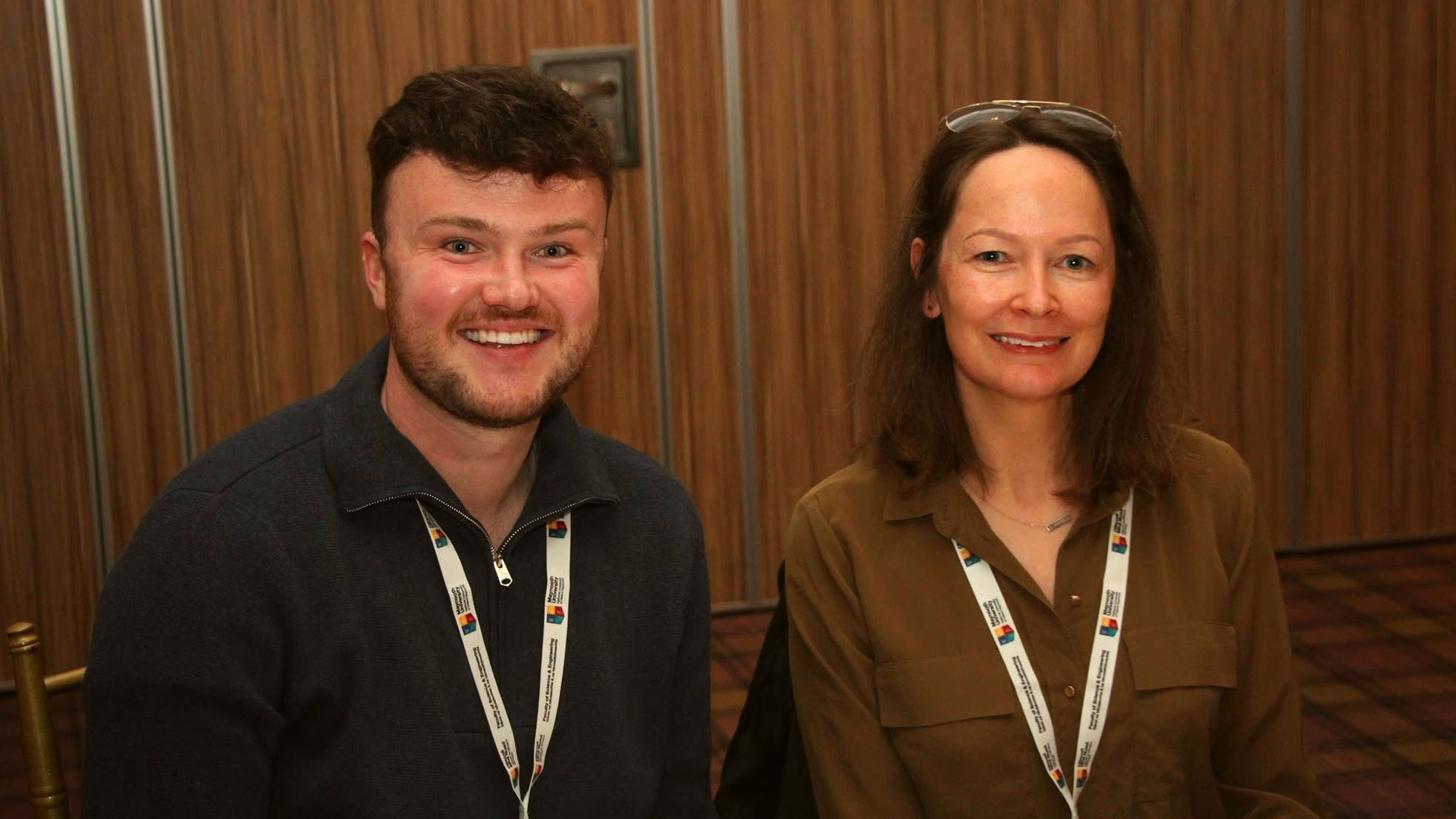 Conor Eivers smiling to camera with a colleague