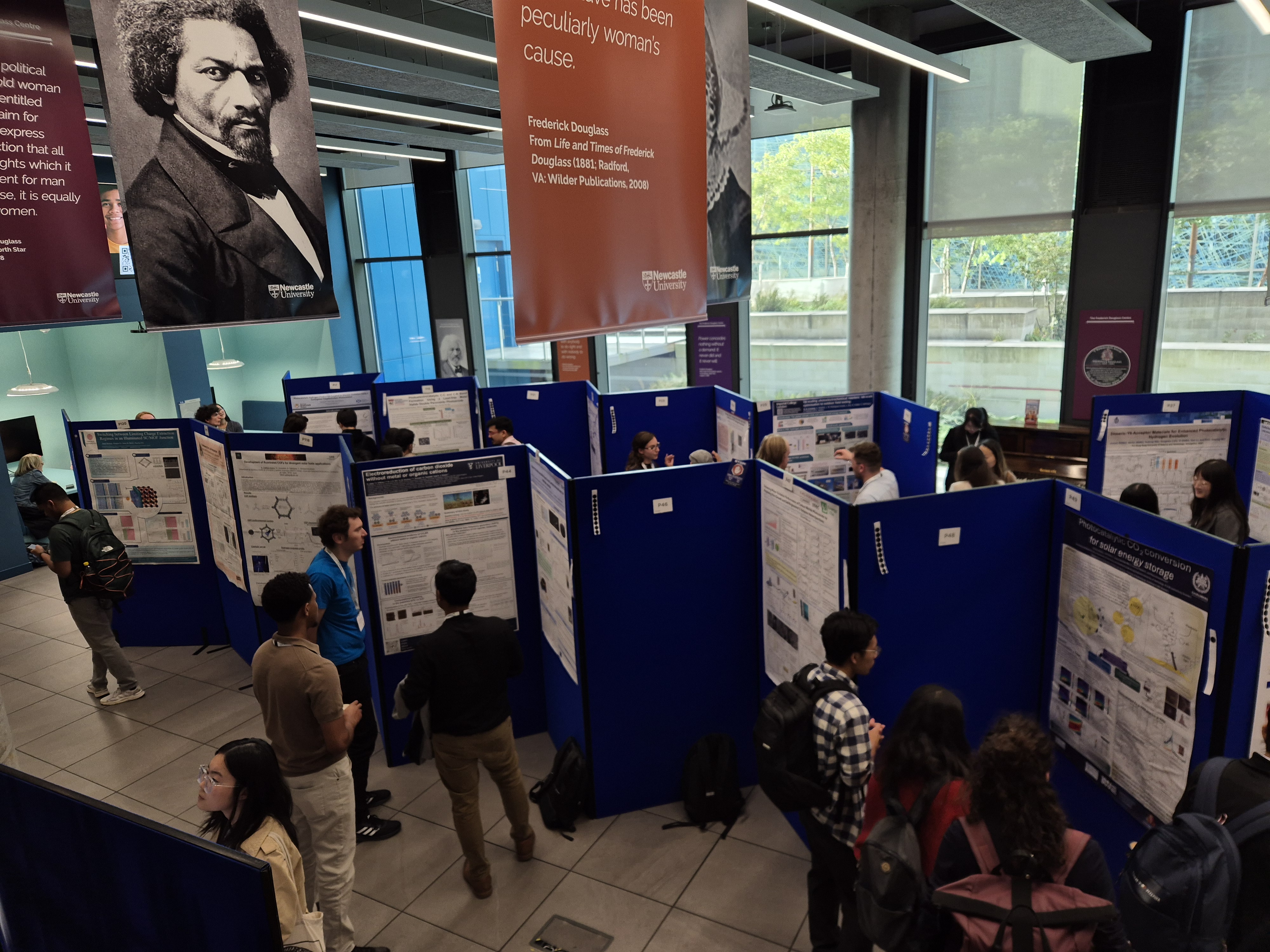 An aerial shot of delegates conversing and looking at materials during the poster session