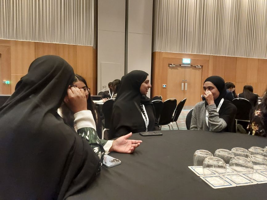 A group of women sit around a table in discussion during a group exercise