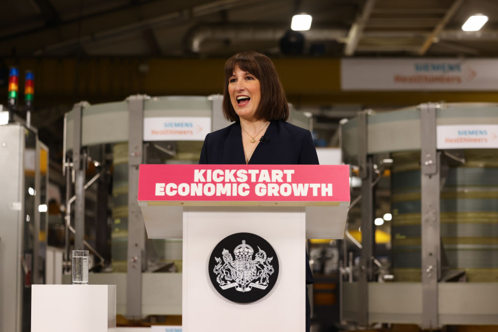 Chancellor of the Exchequer Rachel Reeves MP stands behind a lectern that reads "Kickstart economic growth" in a factory 
