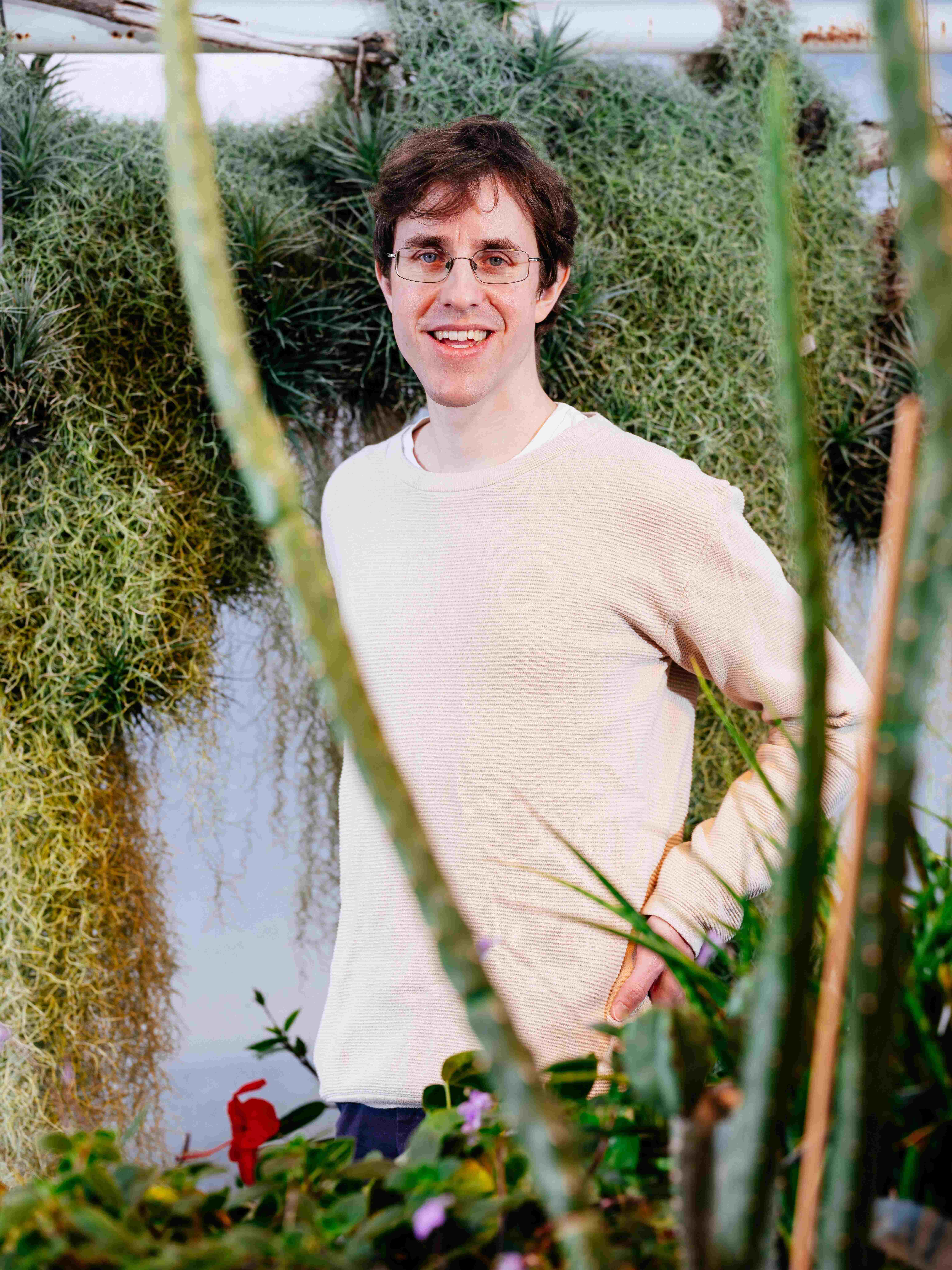 Jakob Franke smiling with glasses on, wearing a beige structured crew neck sweater