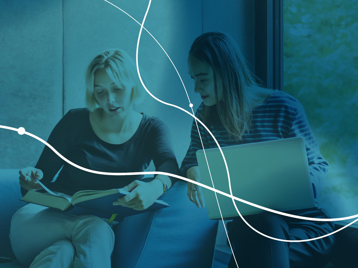 two people sitting looking at a book