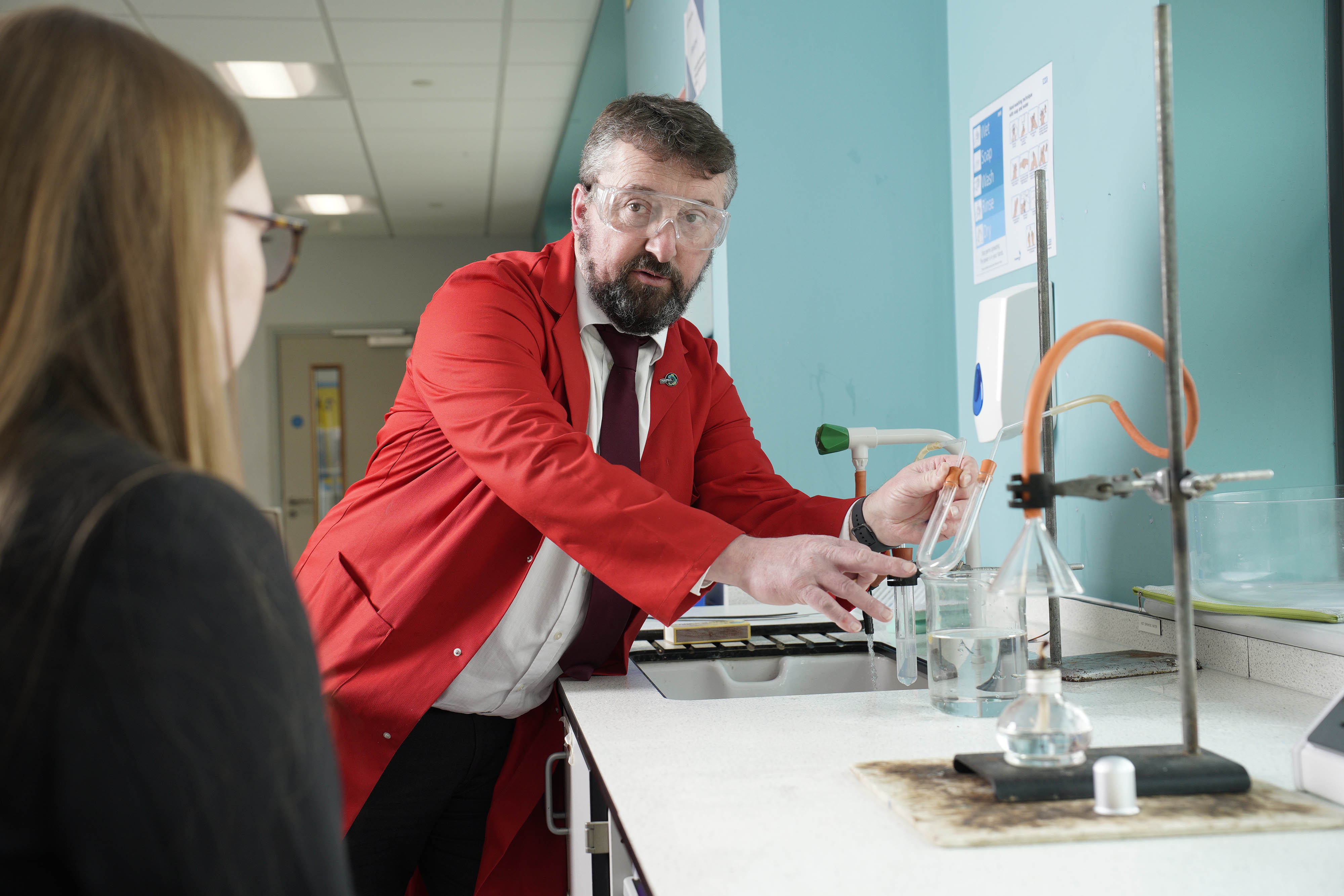 Eurig Thomas, Deputy Head Teacher at Ysgol Cwm Brombil High School in Port Talbot, wearing goggles and holding a beaker